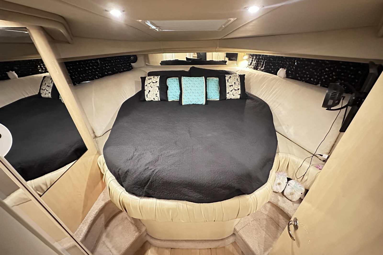 Luxurious interior cabin of 2000 Sea Ray 410 Sundancer yacht with cozy bedding.