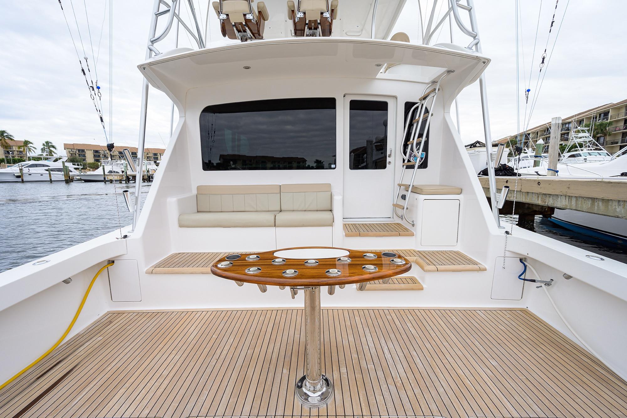 2005 Viking 61 yacht deck with seating and fishing rod holders, docked at marina.