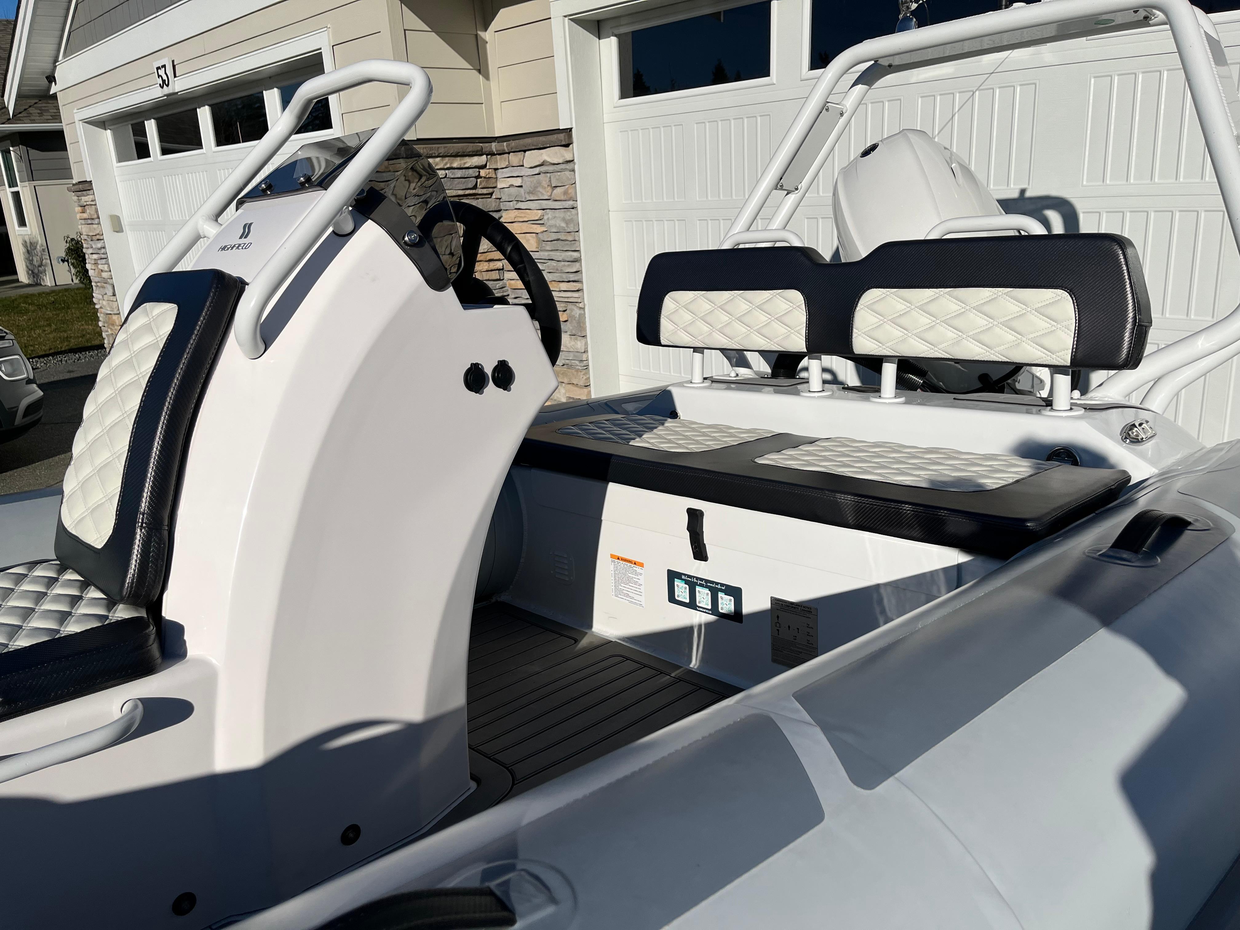 2023 Highfield Sport 420 boat interior with white and black seating, steering console, and modern design.
