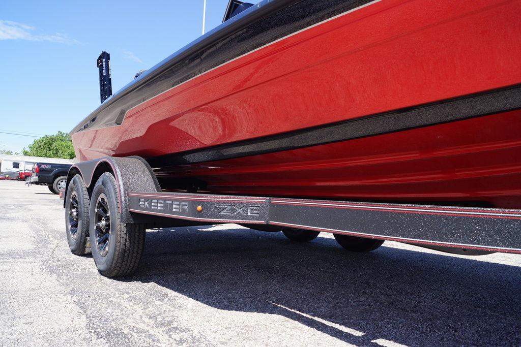 2026 Skeeter ZXE21 boat on trailer, showcasing sleek red design and dual axles.
