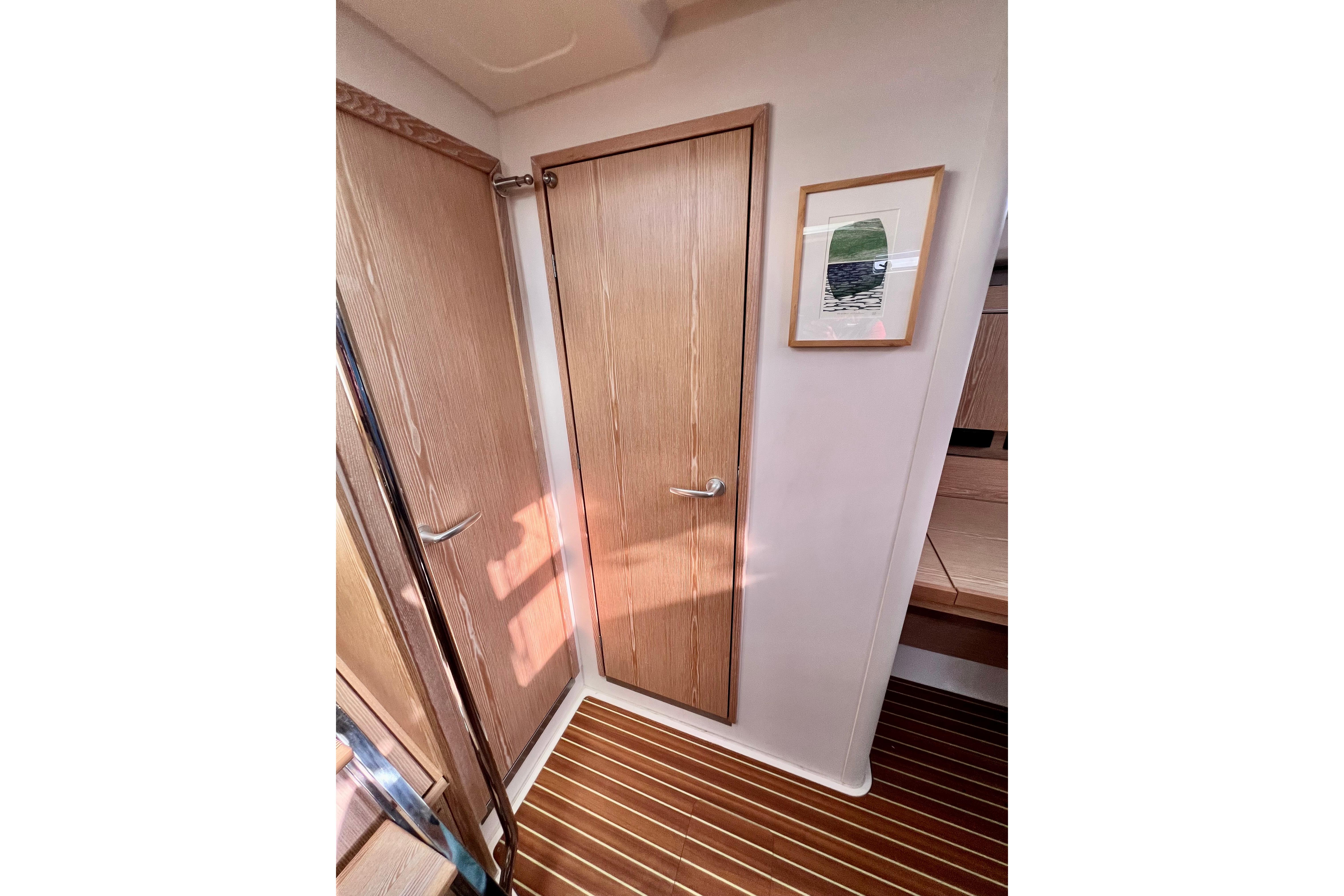 Interior of 2016 Hanse 455 yacht with wooden door and framed artwork.