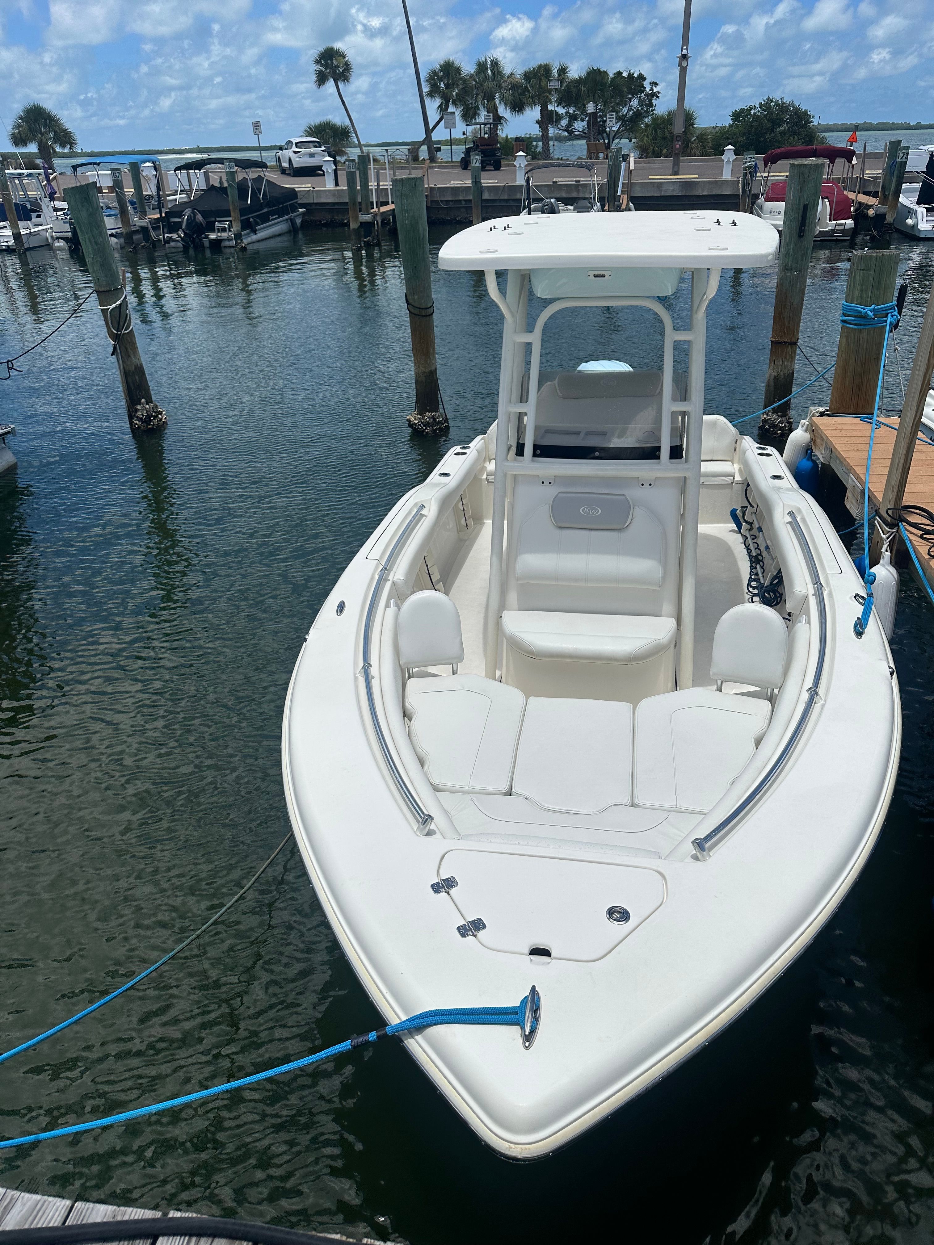 A white boat is docked in a calm harbor.