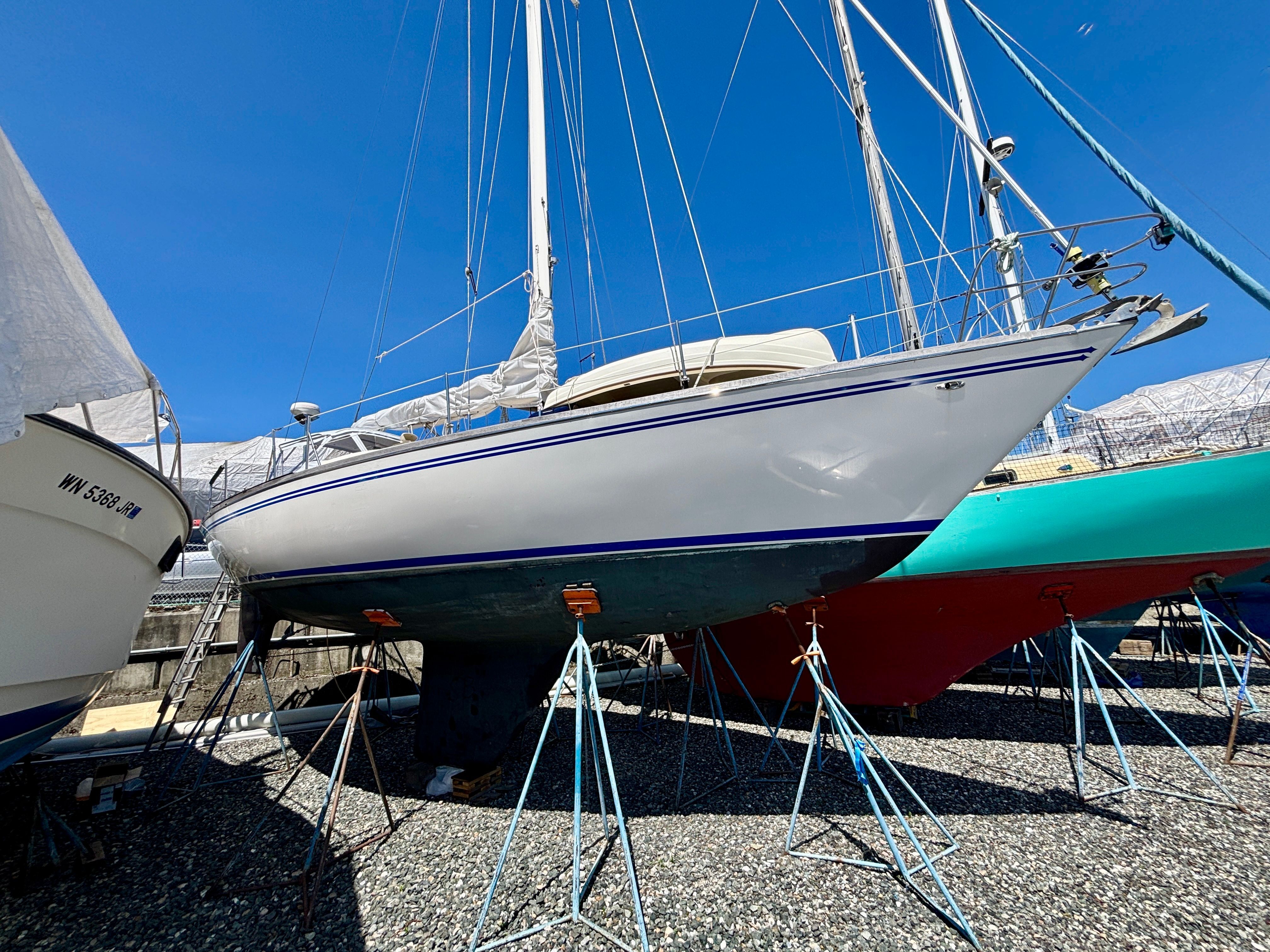 A 1979 Tartan 37 sailboat is on a dry dock, supported by stands.