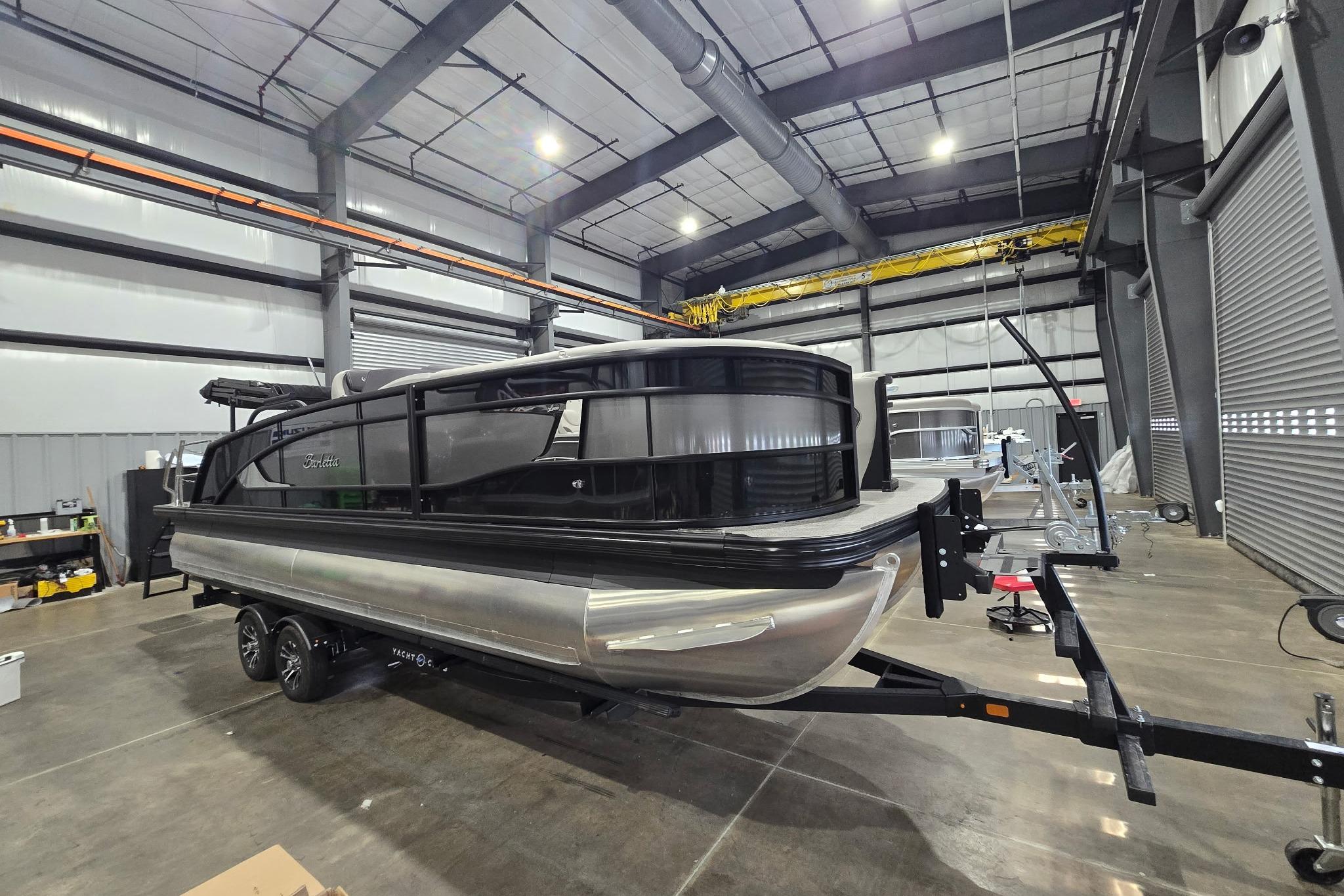2025 Barletta Lusso 23UC pontoon boat in a spacious indoor facility.