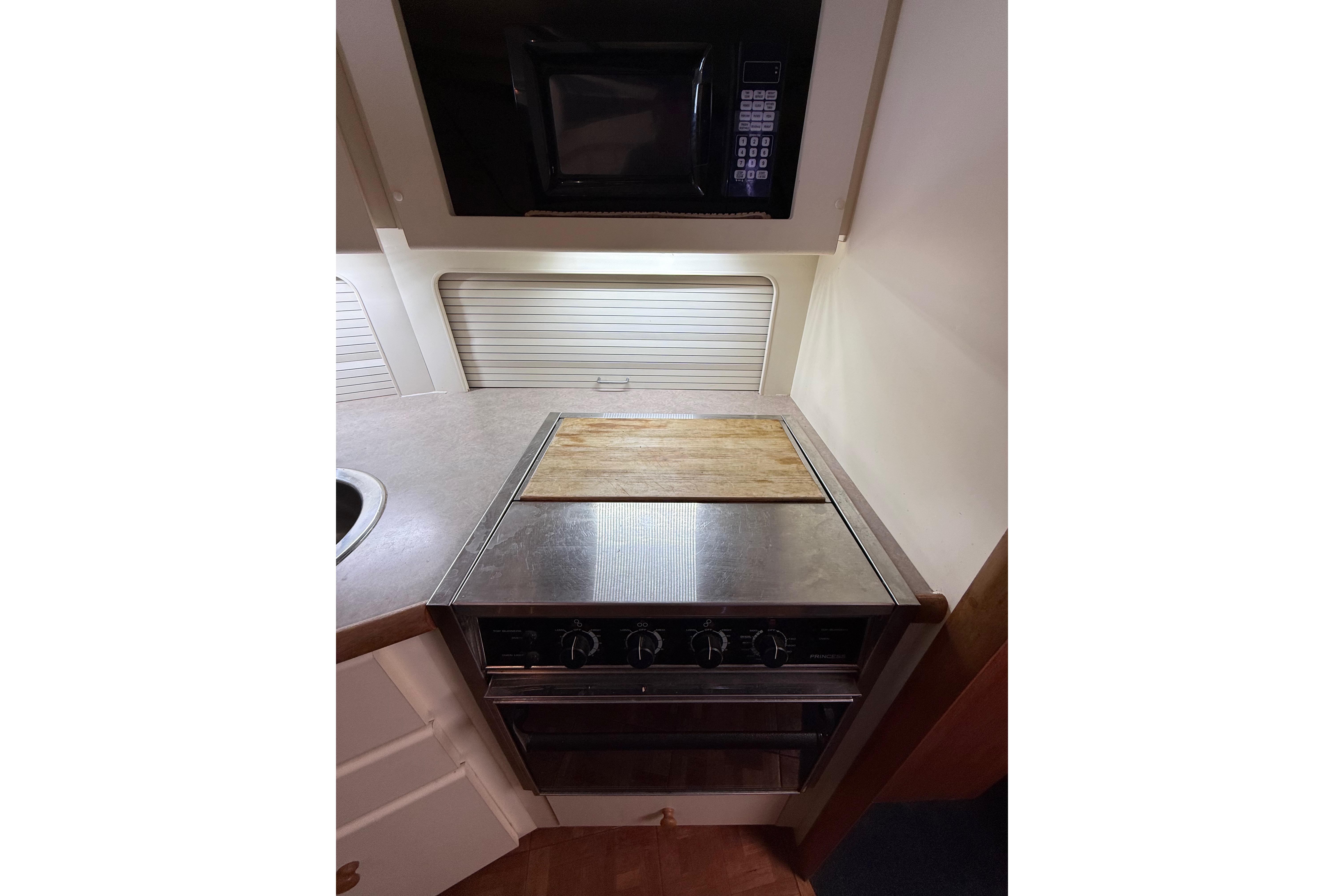 Compact kitchen area in a 1996 Carver 400 Cockpit Motor Yacht with stove and microwave.