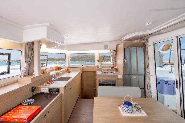 Modern kitchen interior of 2025 Lagoon 38 catamaran with ocean view.
