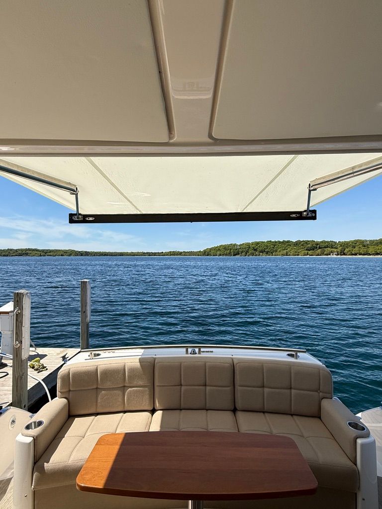 View from a Tiara Yachts C44 Coupe overlooking the water, with a sofa and table in the foreground.