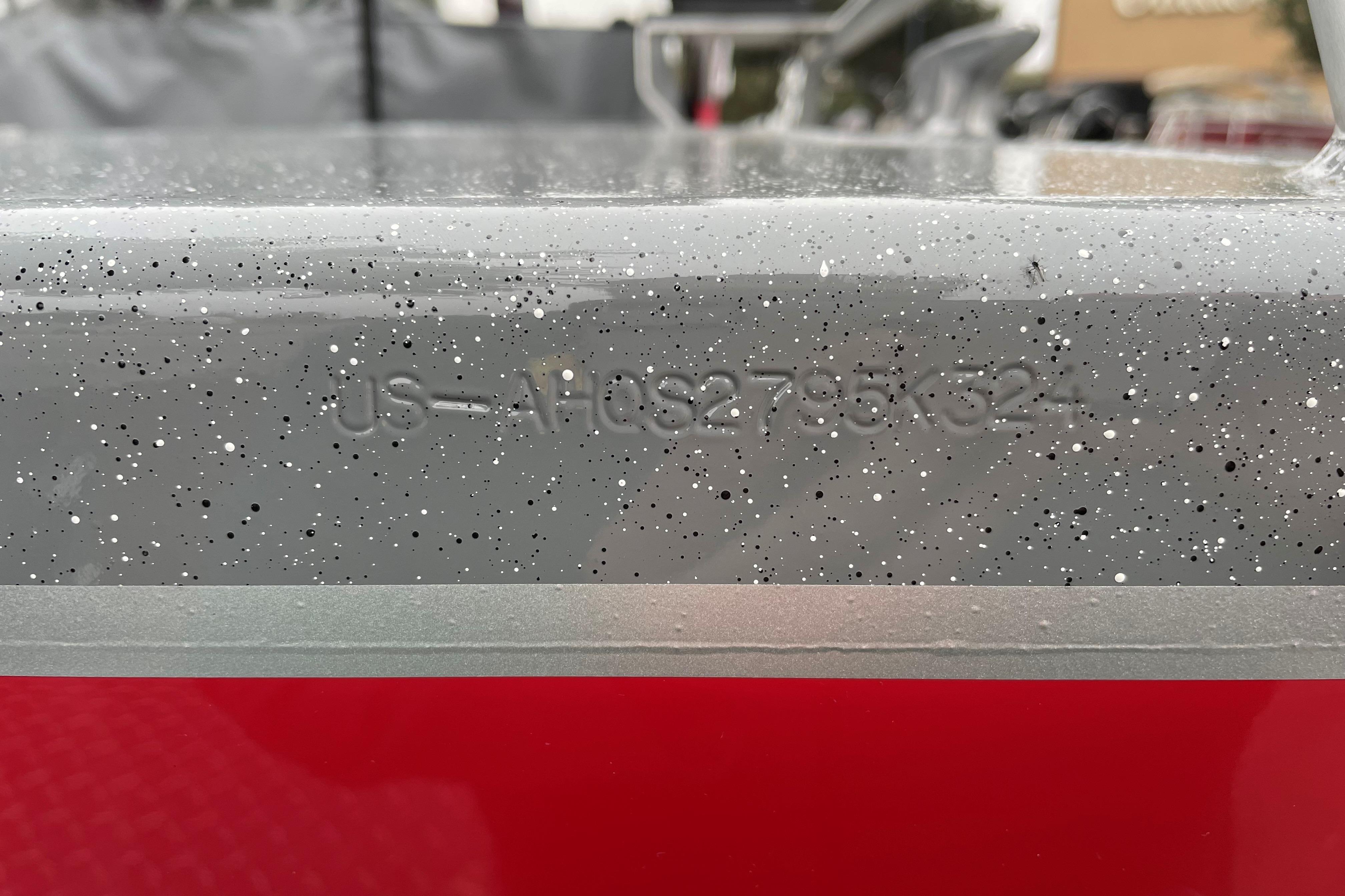 2024 Spartan 200 Astoria boat hull identification number on speckled gray surface.