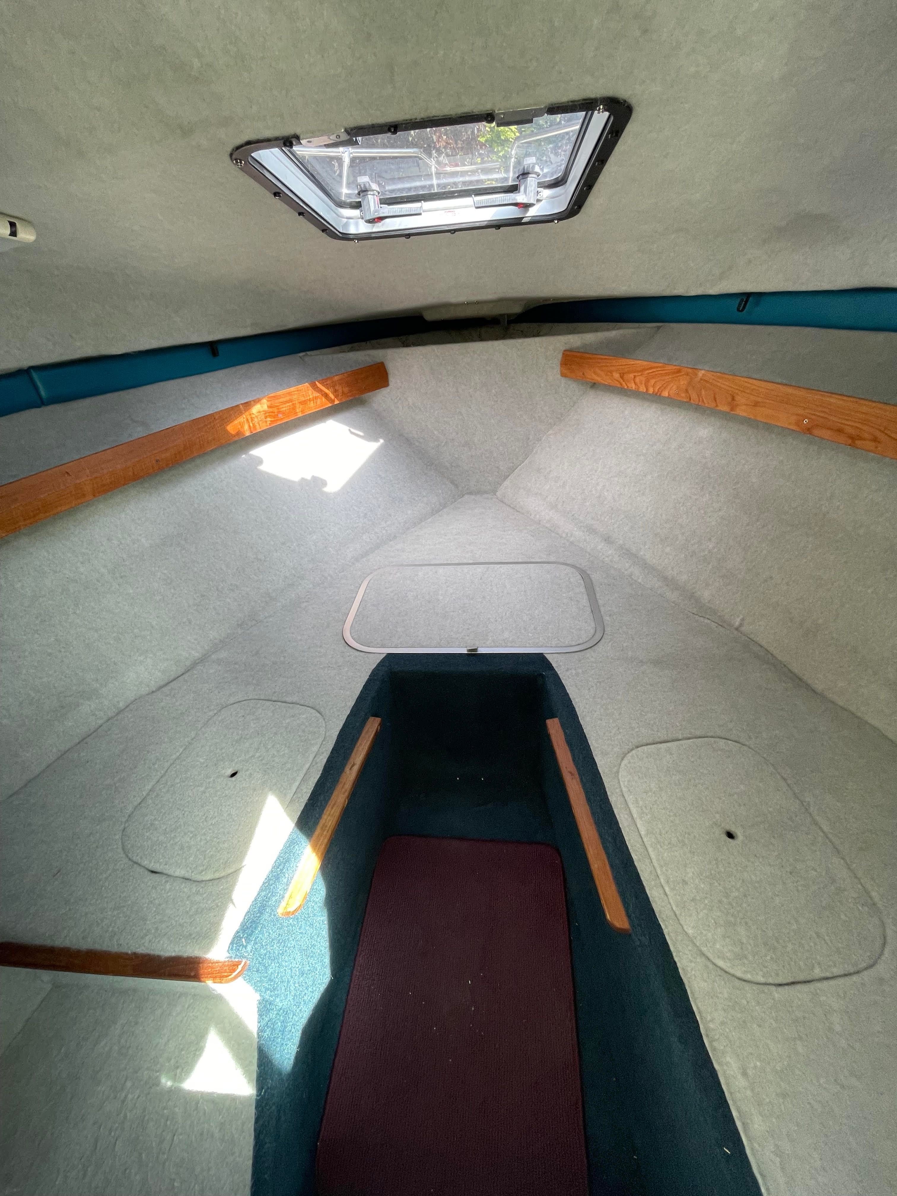 Interior of a 1991 Bayliner 2159 with gray carpeting and wooden accents.