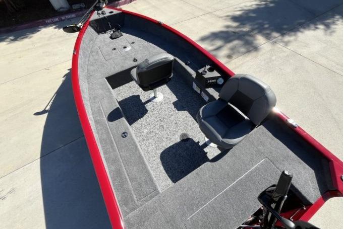 2025 Tracker Super Guide V-16 T fishing boat with red exterior and two gray seats.