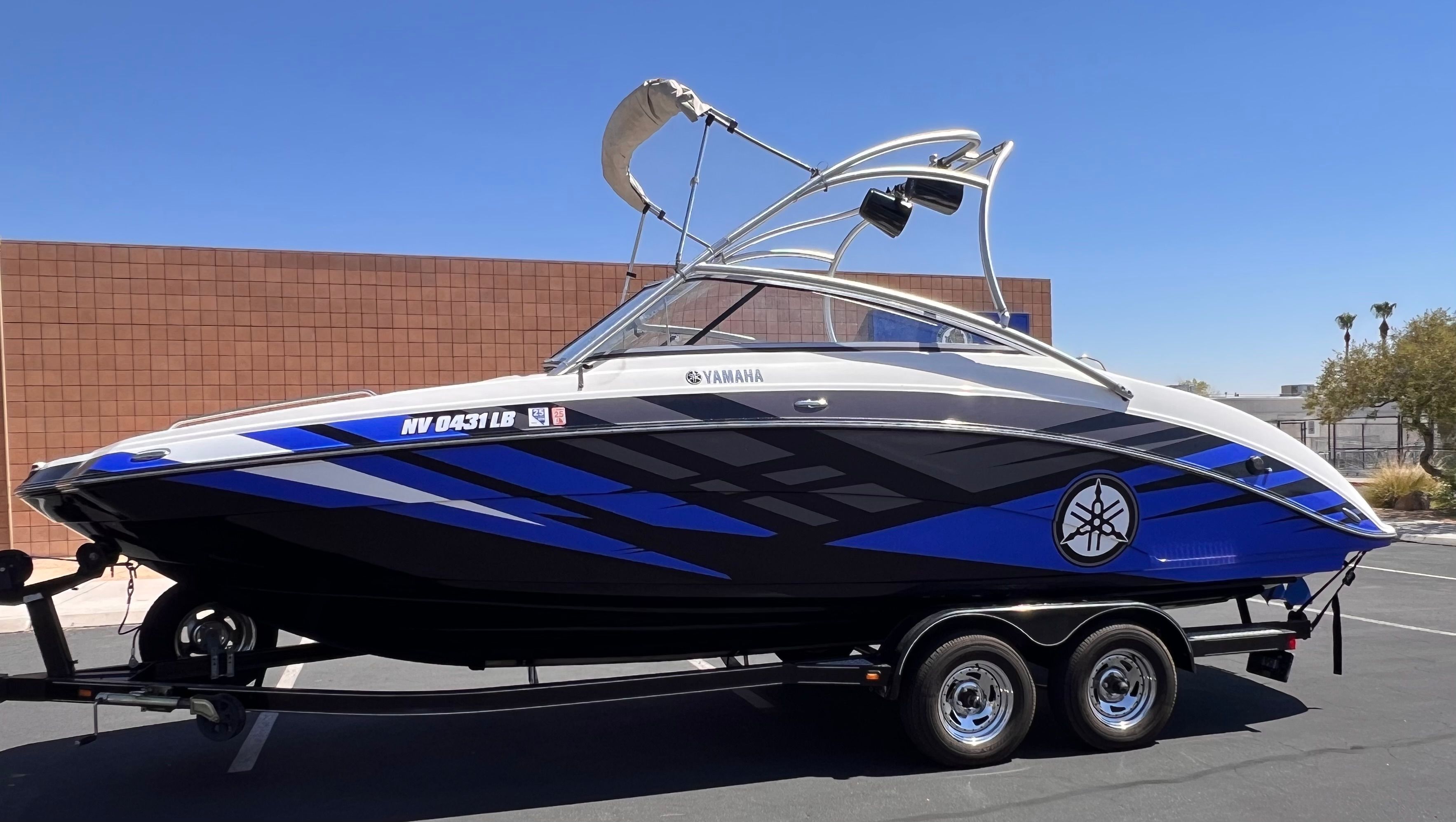 2011 Yamaha AR240 HO boat on trailer, blue and black, side view.