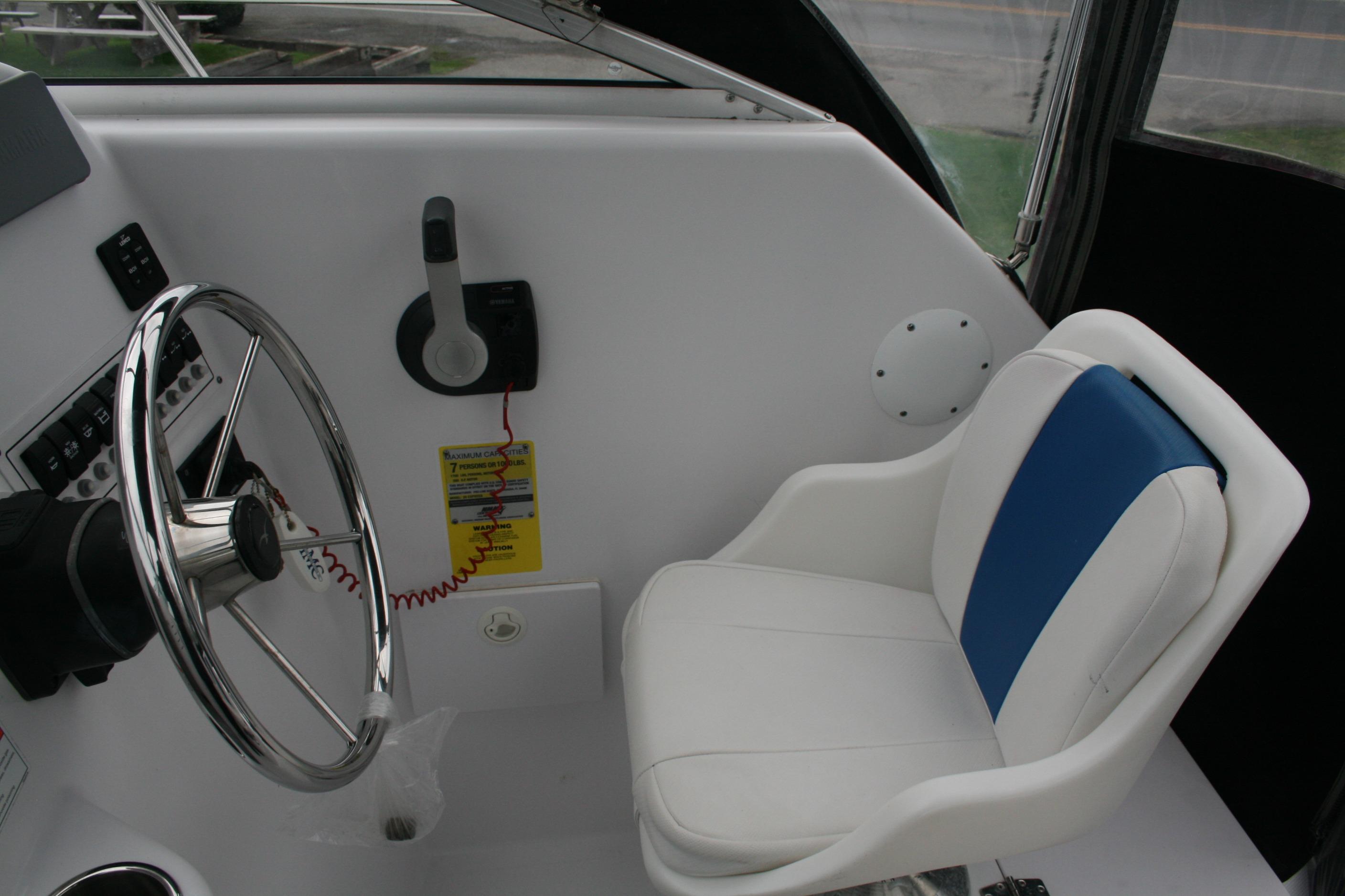 2013 Pro-Line 20 Express boat interior with steering wheel and white-blue captain's chair.