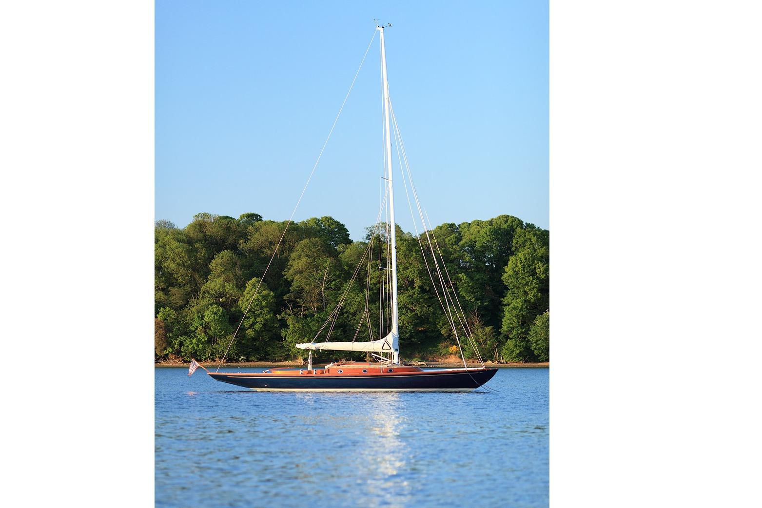 Sailing yacht Spirit Yachts R46, 2010 model, on calm water with lush green backdrop.