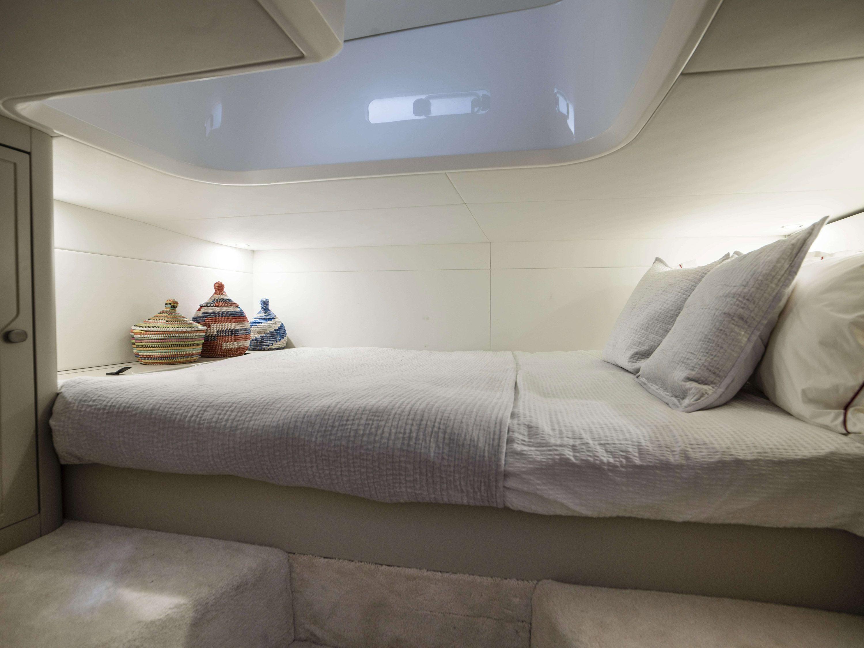Luxurious cabin interior of 2021 Fairline F Line 33 yacht with cozy bed.