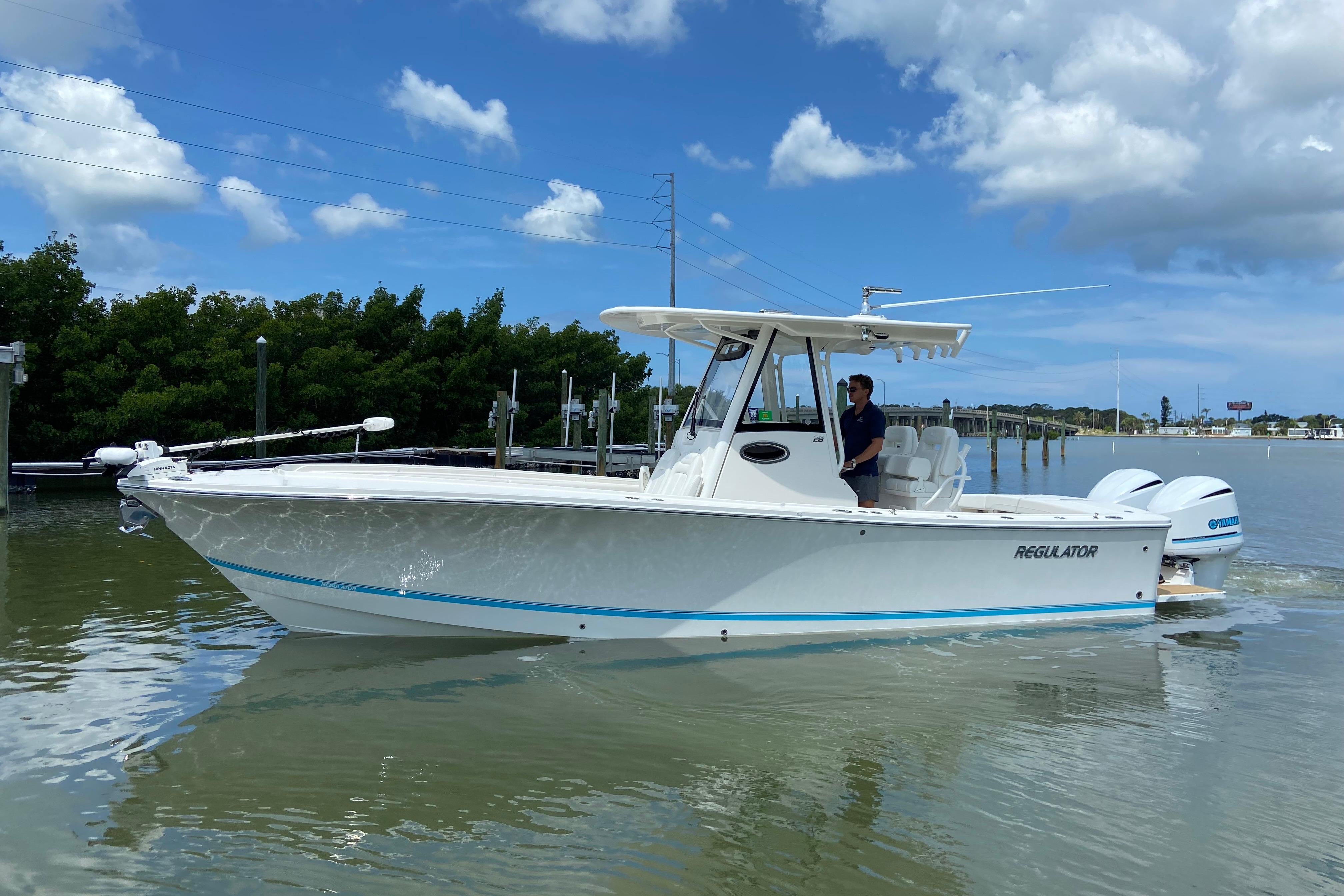 2021 Regulator 28 boat cruising on calm water under a clear blue sky.