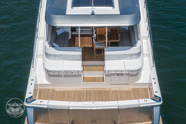 2025 Riviera 645 SUV luxury yacht, rear view, docked on water.