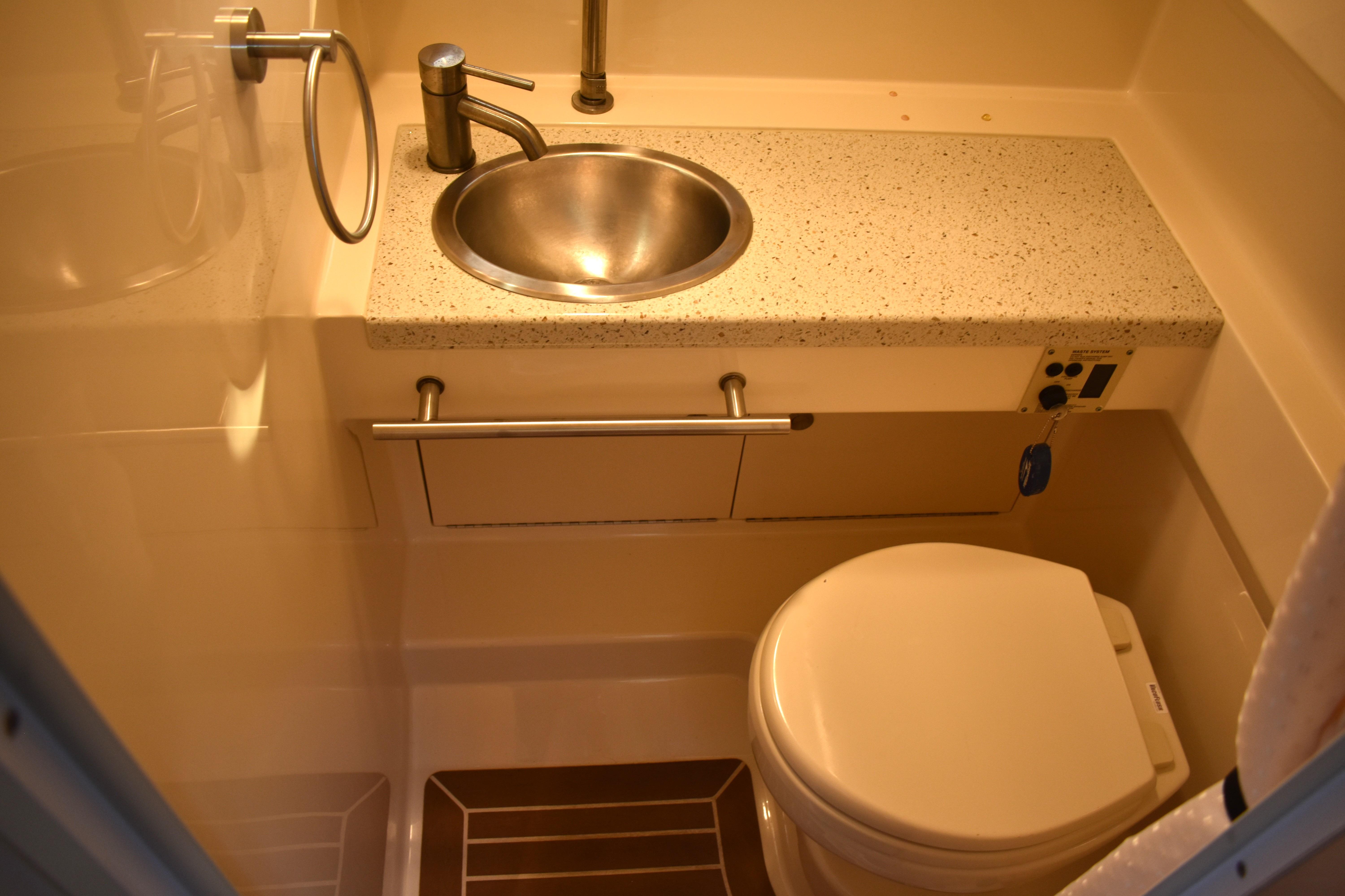 Compact bathroom in 2016 Sea Ray Sundancer 310 yacht with sink and toilet.