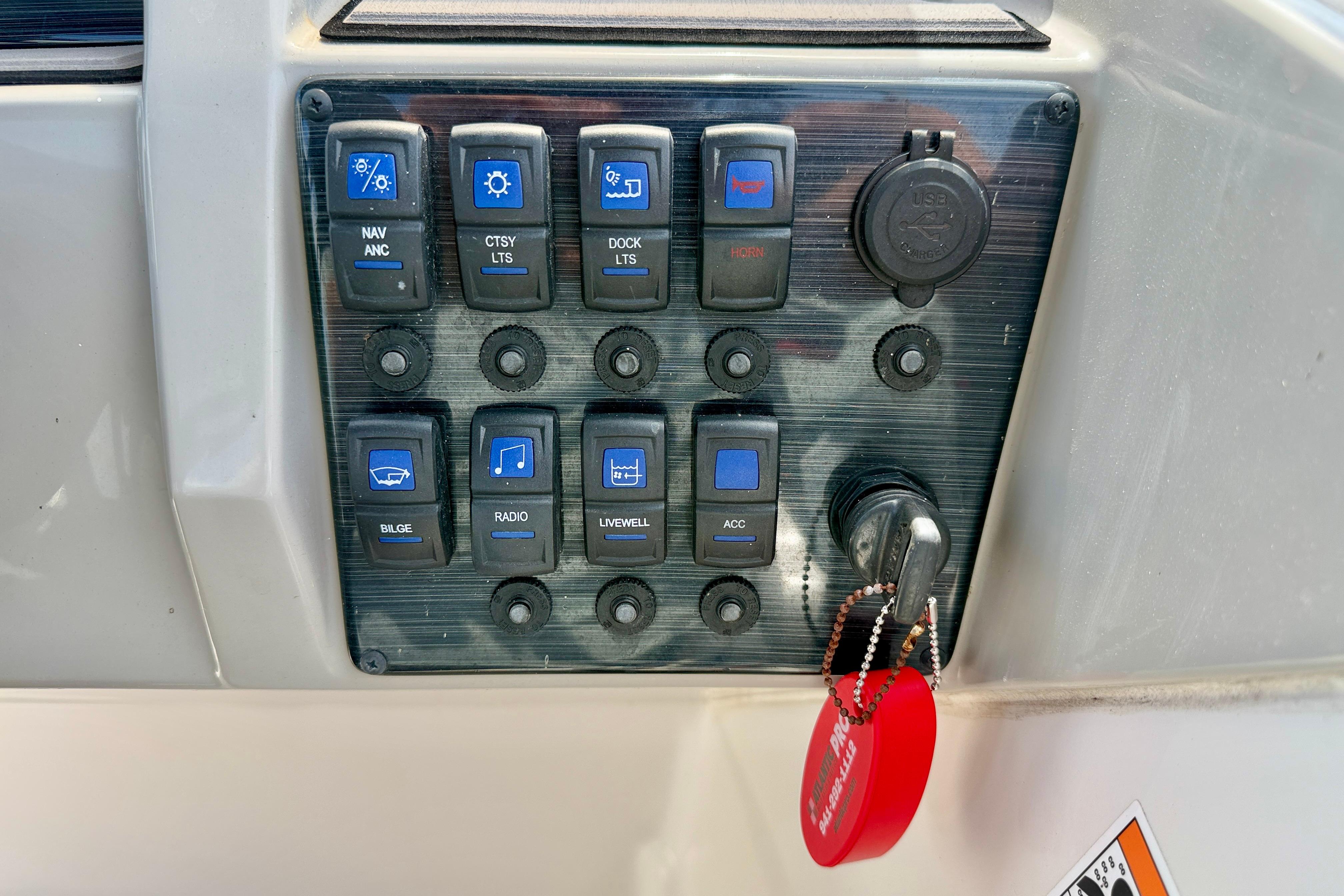 Control panel of 2021 Starcraft SVX 191 OB boat with labeled switches and ignition key.
