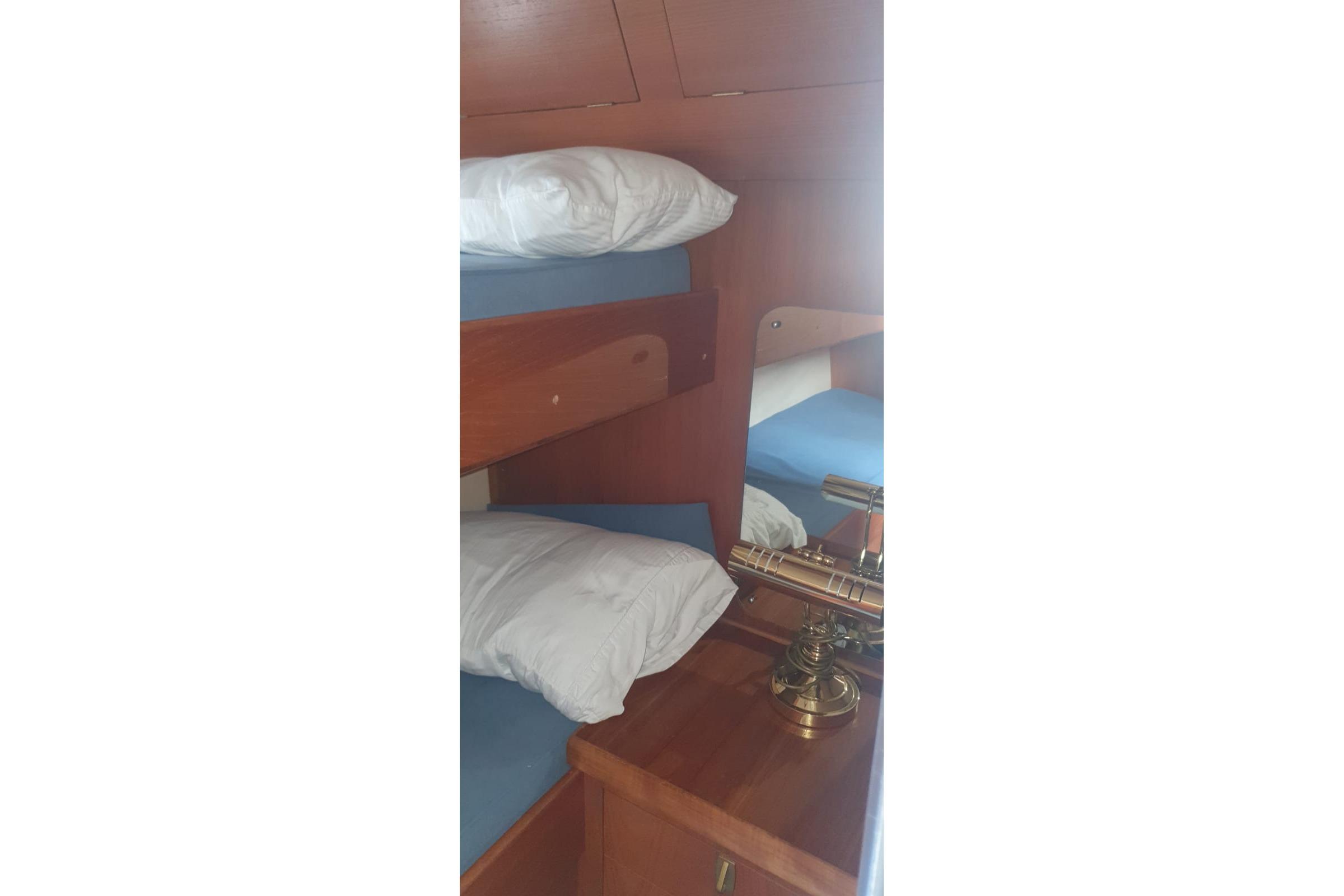 Interior of 1989 Princess 35 yacht with wooden bunk beds and brass lamp.