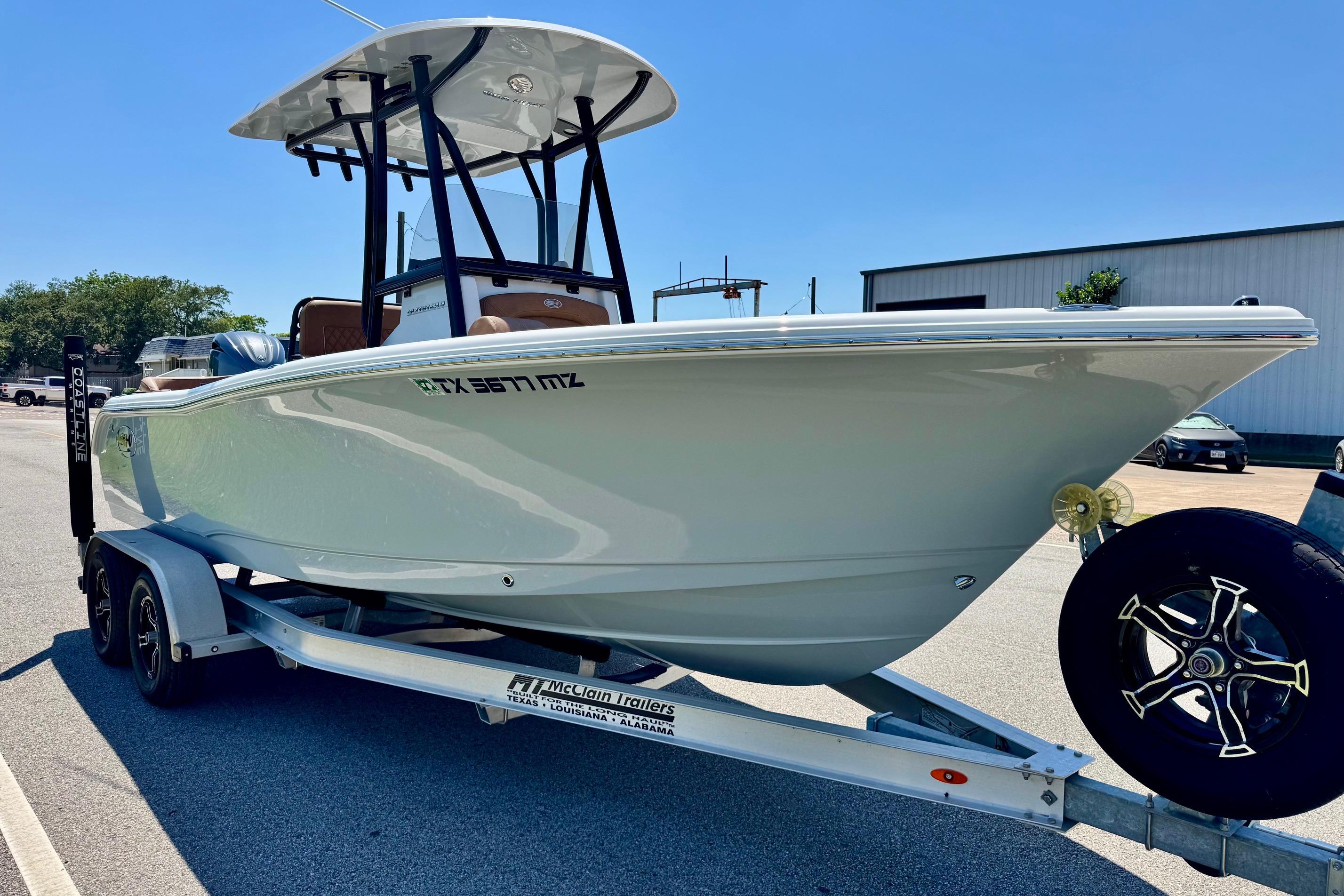 2025 Sea Hunt Ultra 219 boat on trailer, parked outdoors under clear sky.