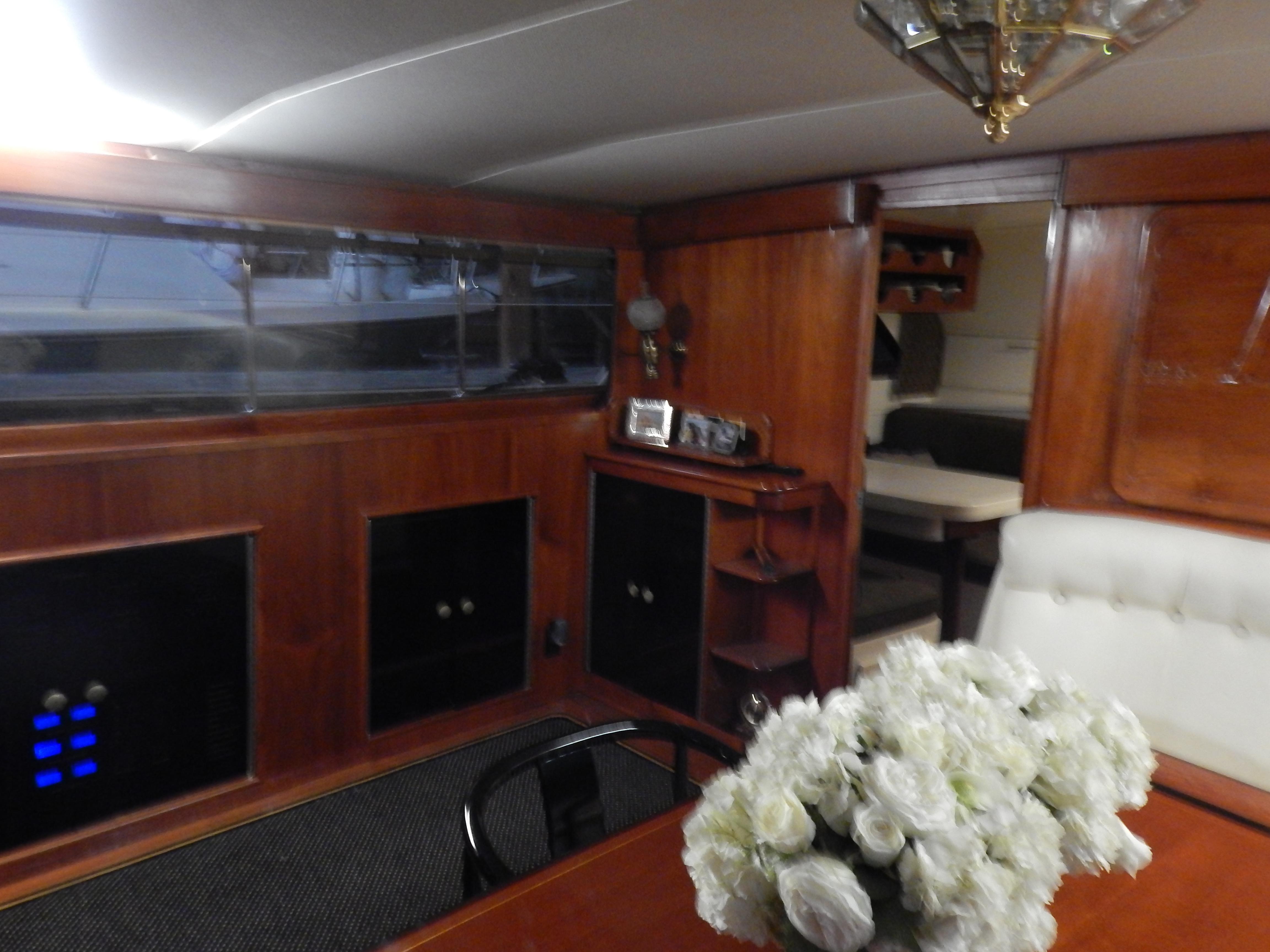 1974 Pacemaker Cockpit Motoryacht interior with wood paneling and floral centerpiece.