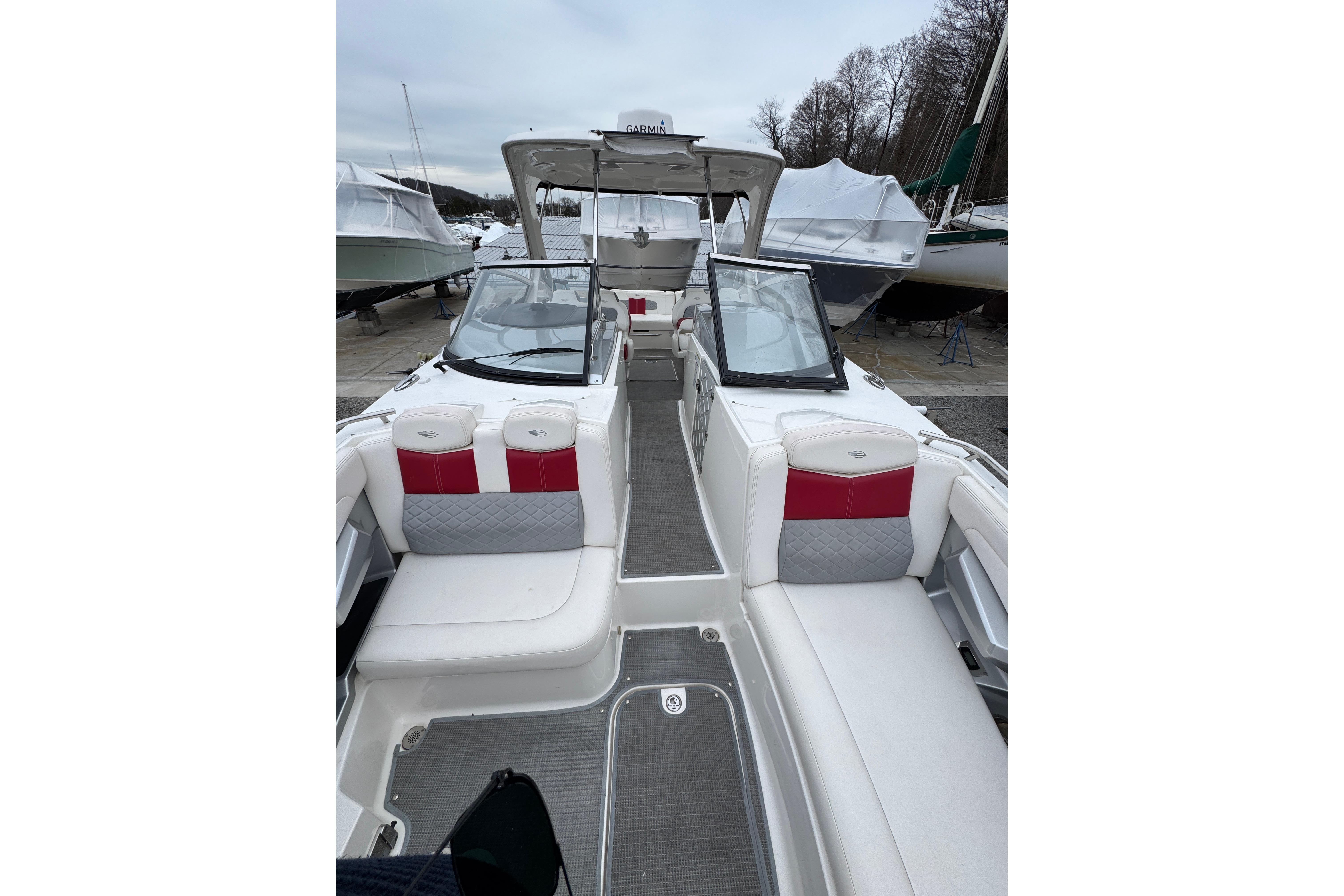 2012 Chaparral 327 SSX boat interior with white and red seating, docked outdoors.
