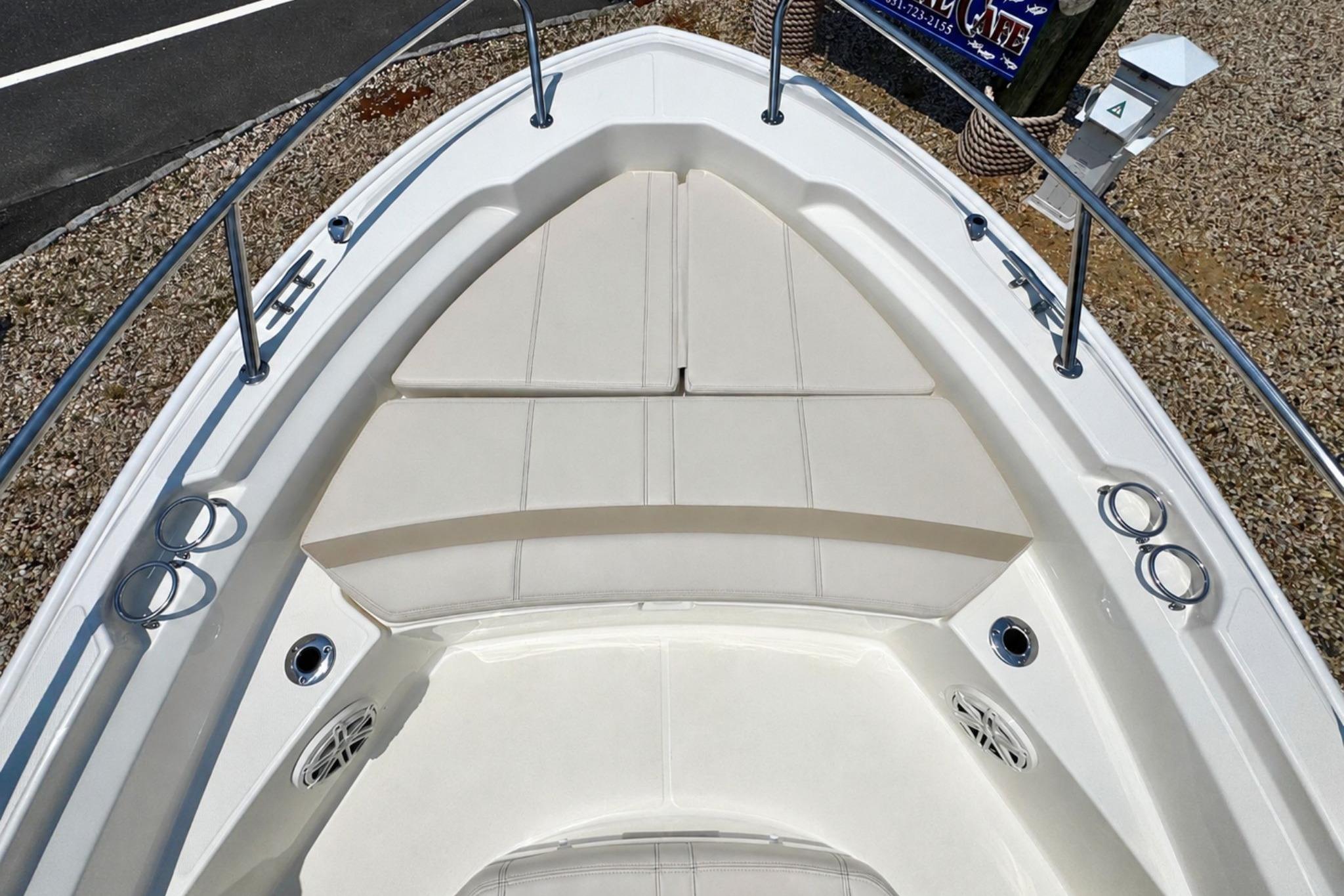 2026 Boston Whaler 220 Dauntless boat interior with cushioned seating and stainless steel railings.