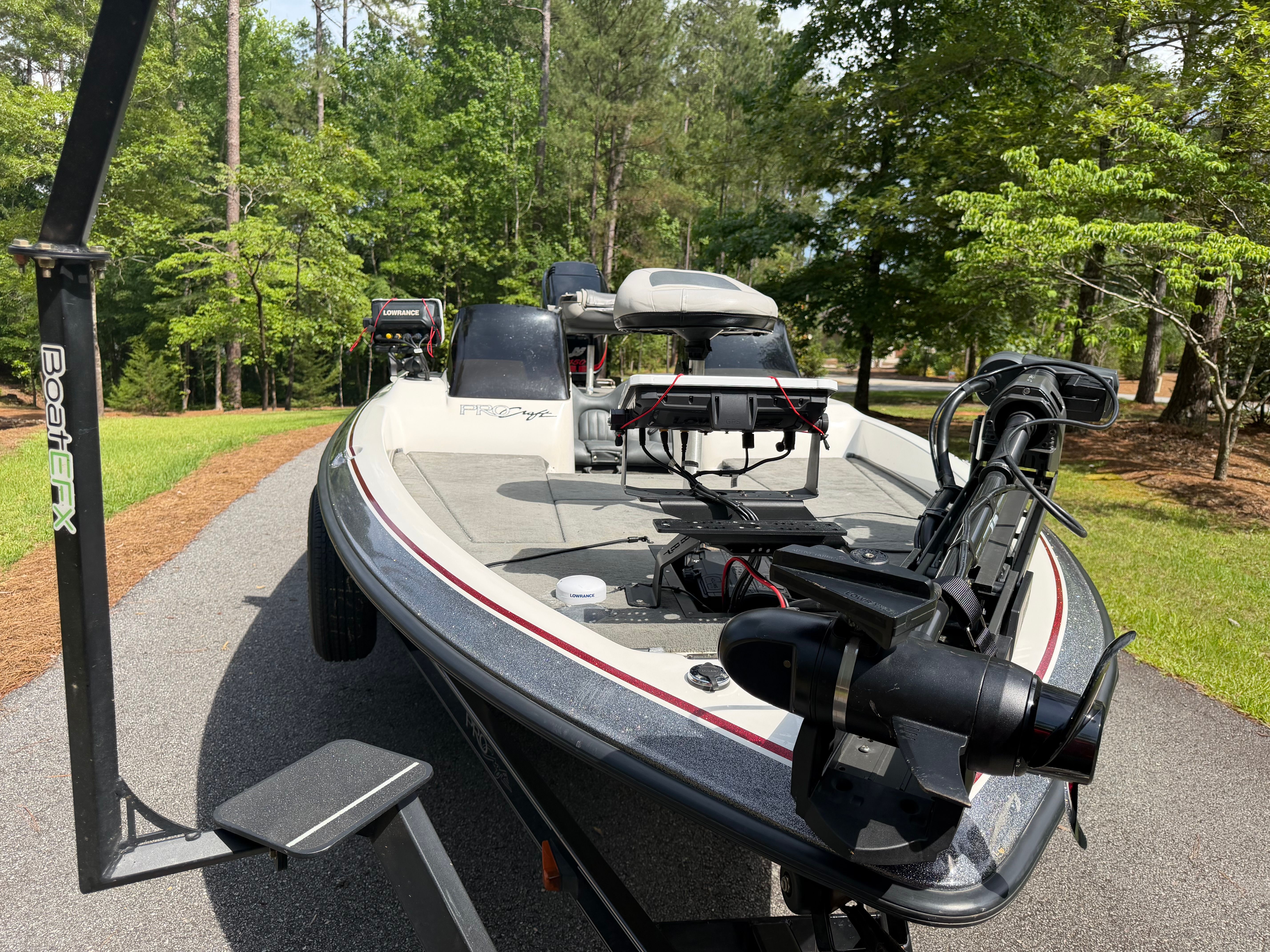 A 2001 ProCraft Pro 185 SC/DC boat on a trailer, surrounded by trees.