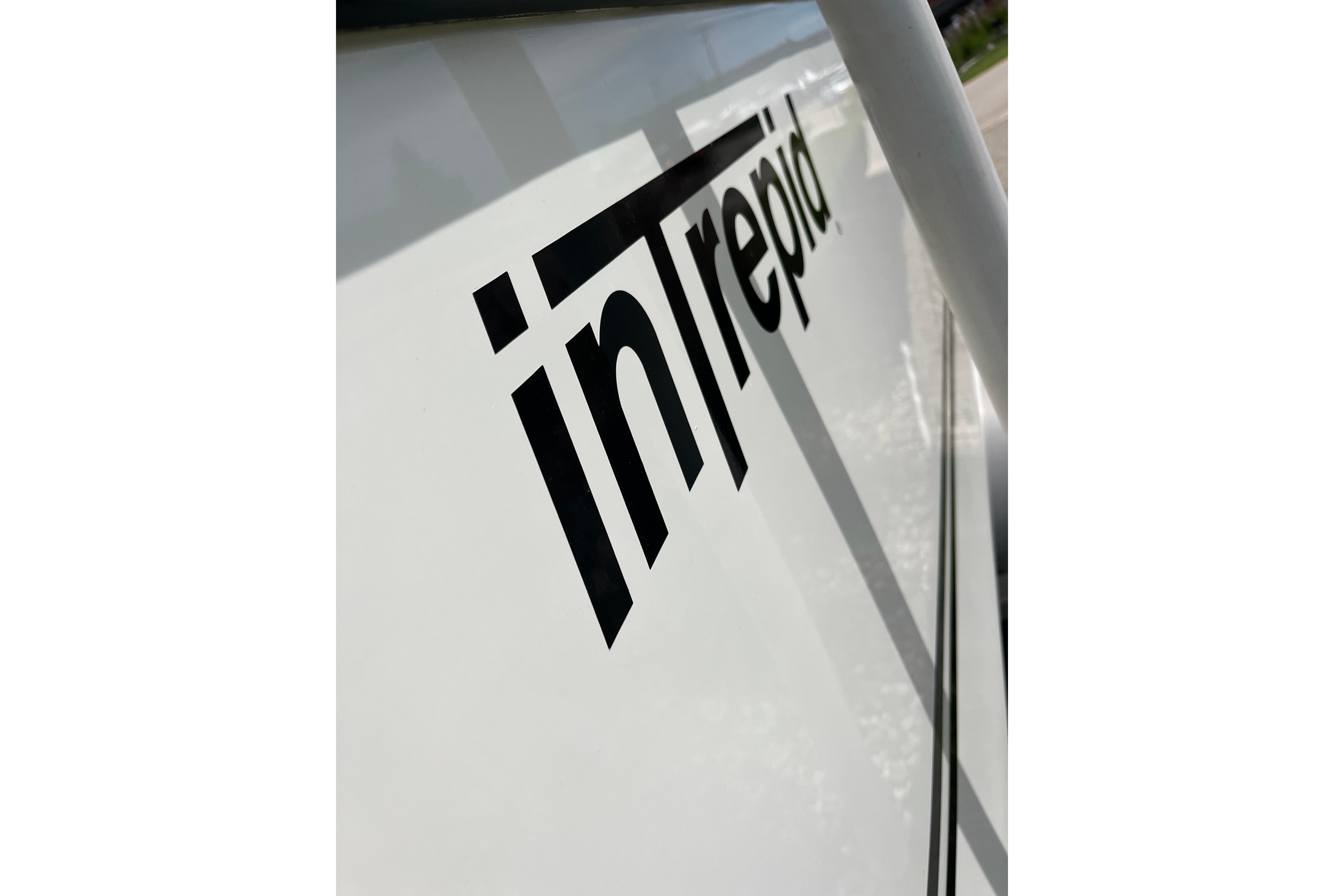 Close-up of 1994 Intrepid 30 Open Cuddy boat logo on white hull.