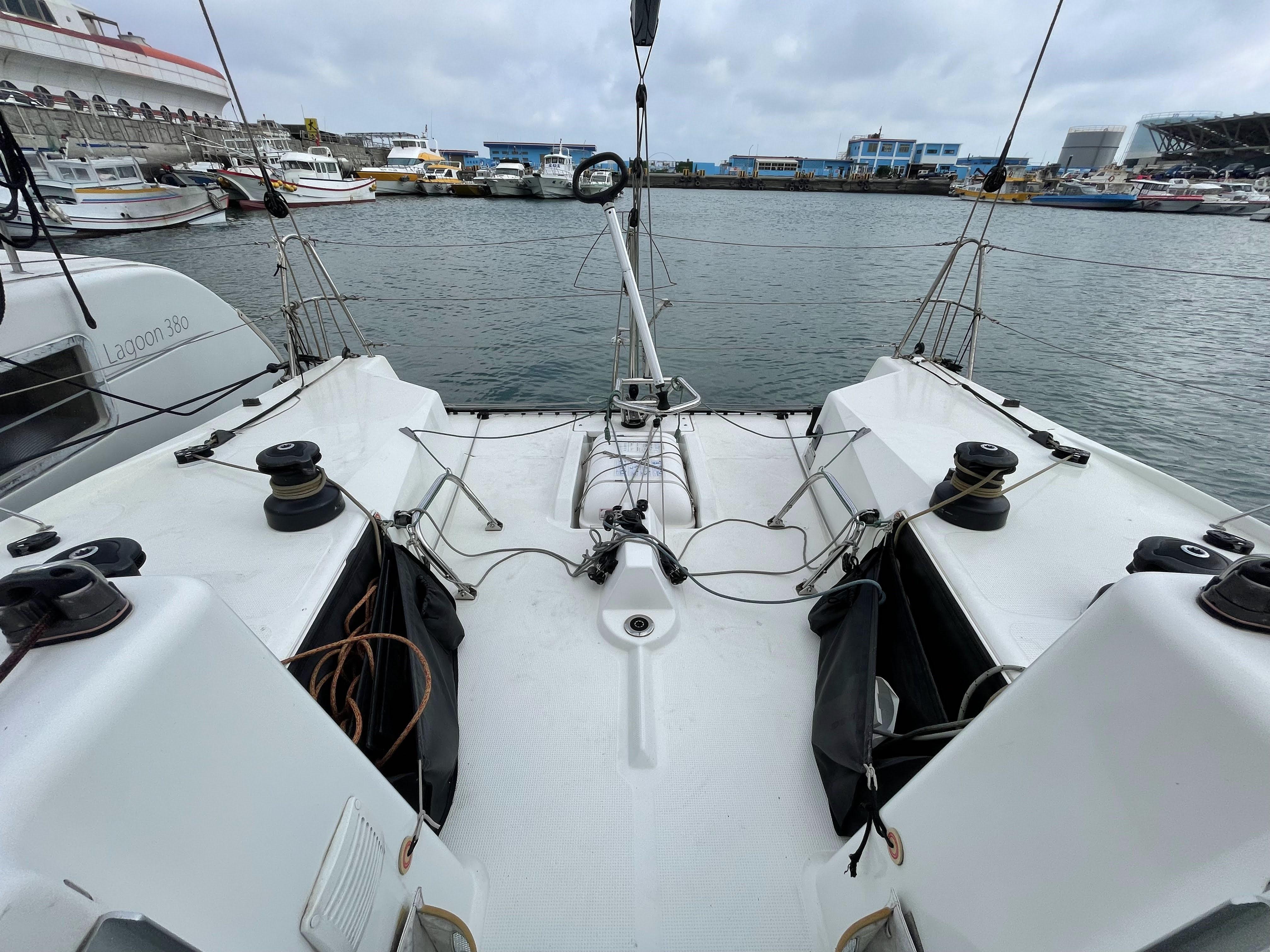 Beneteau Figaro 3 sailboat cockpit, 2018 model, docked in a marina with overcast skies.