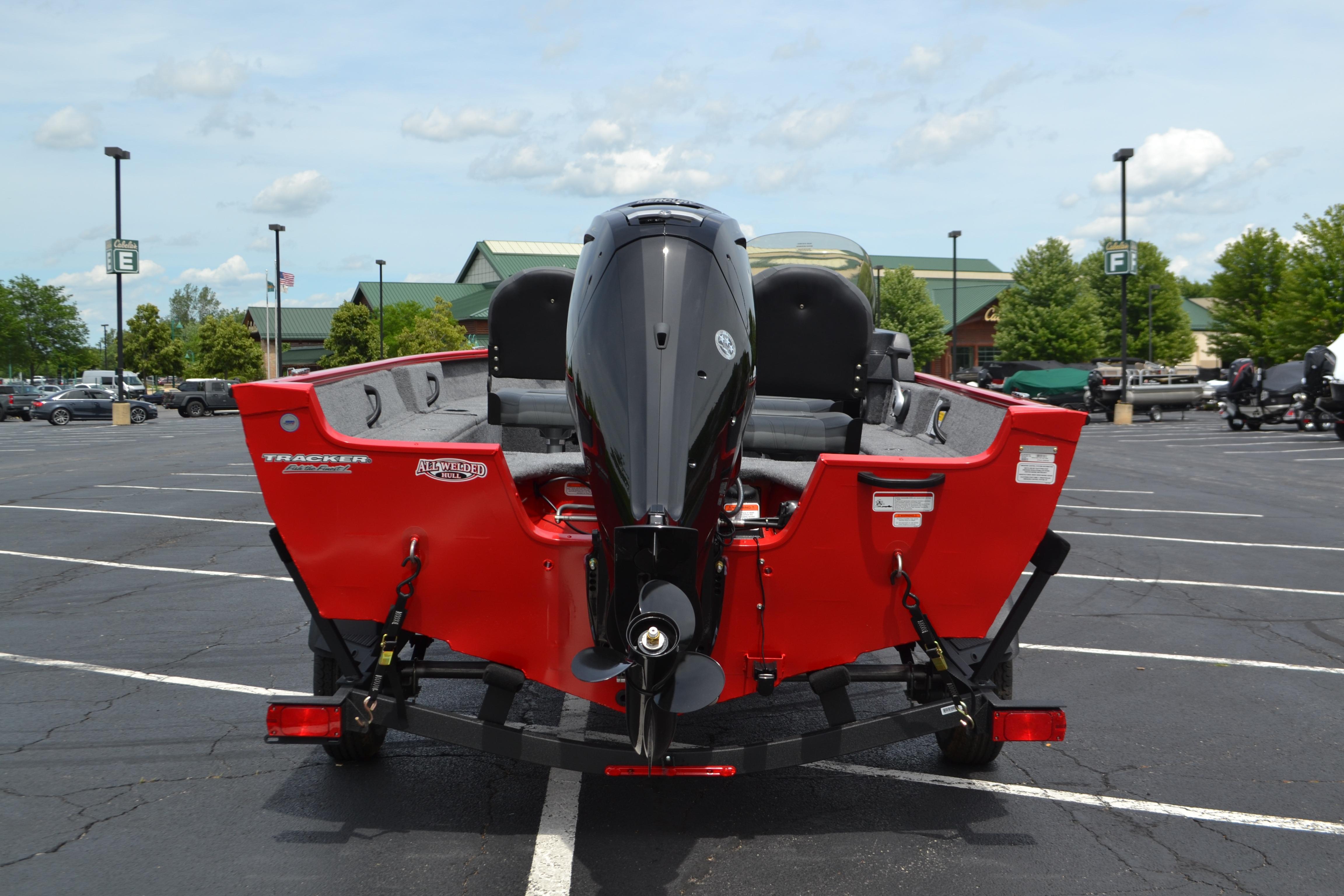 2026 Tracker Pro Guide V-16 SC boat, red exterior, parked in a lot.