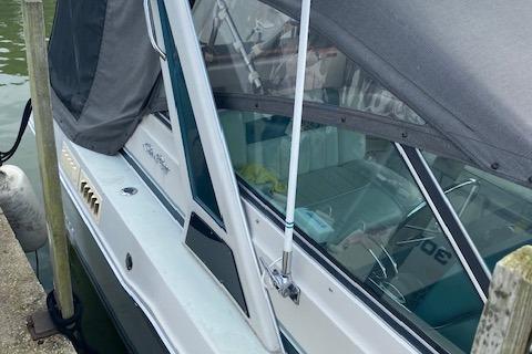 1987 Sea Ray 300 Weekender boat docked, featuring a covered cabin and sleek design.