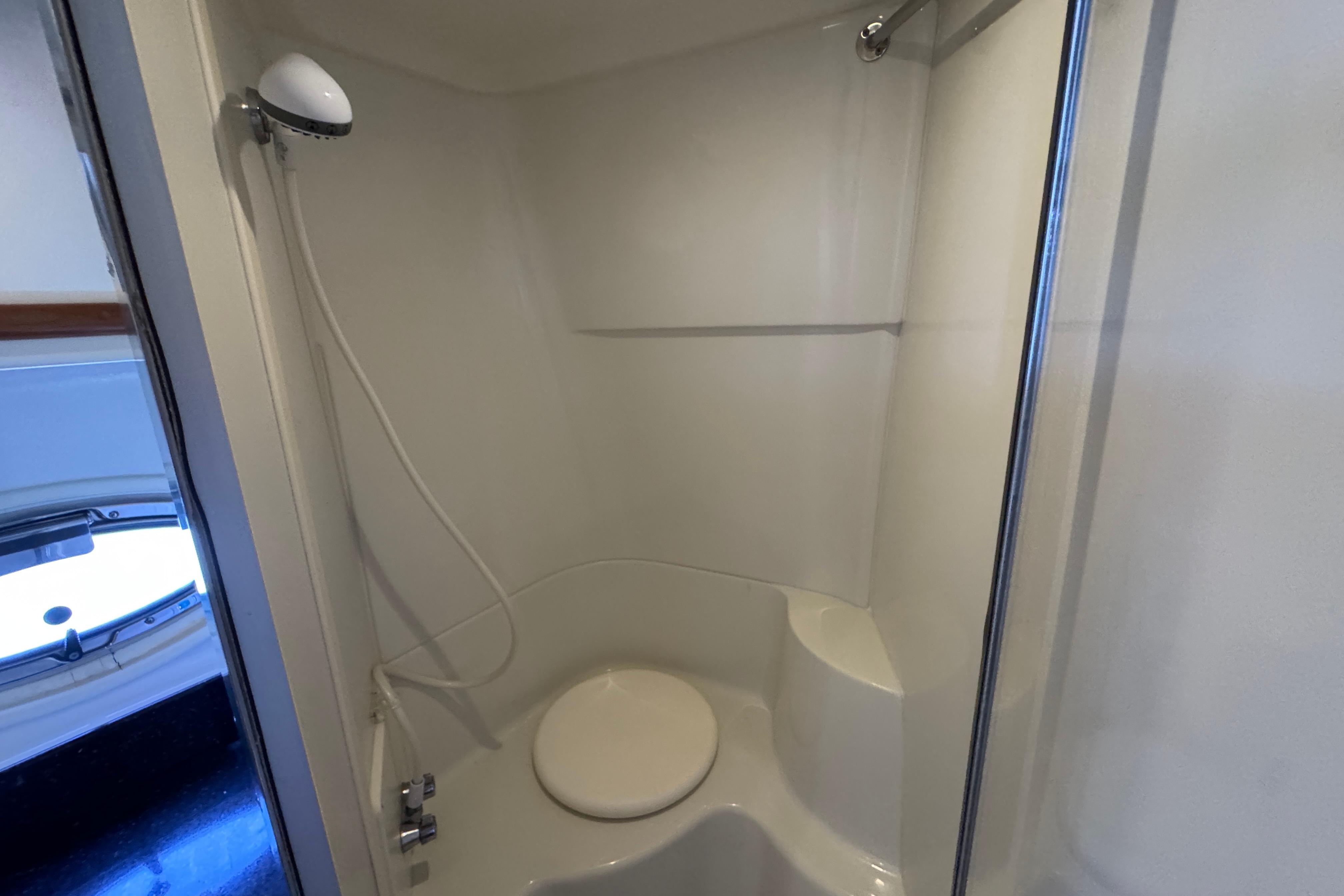 Shower area in 2002 Carver 396 Motor Yacht, featuring a compact design and handheld showerhead.