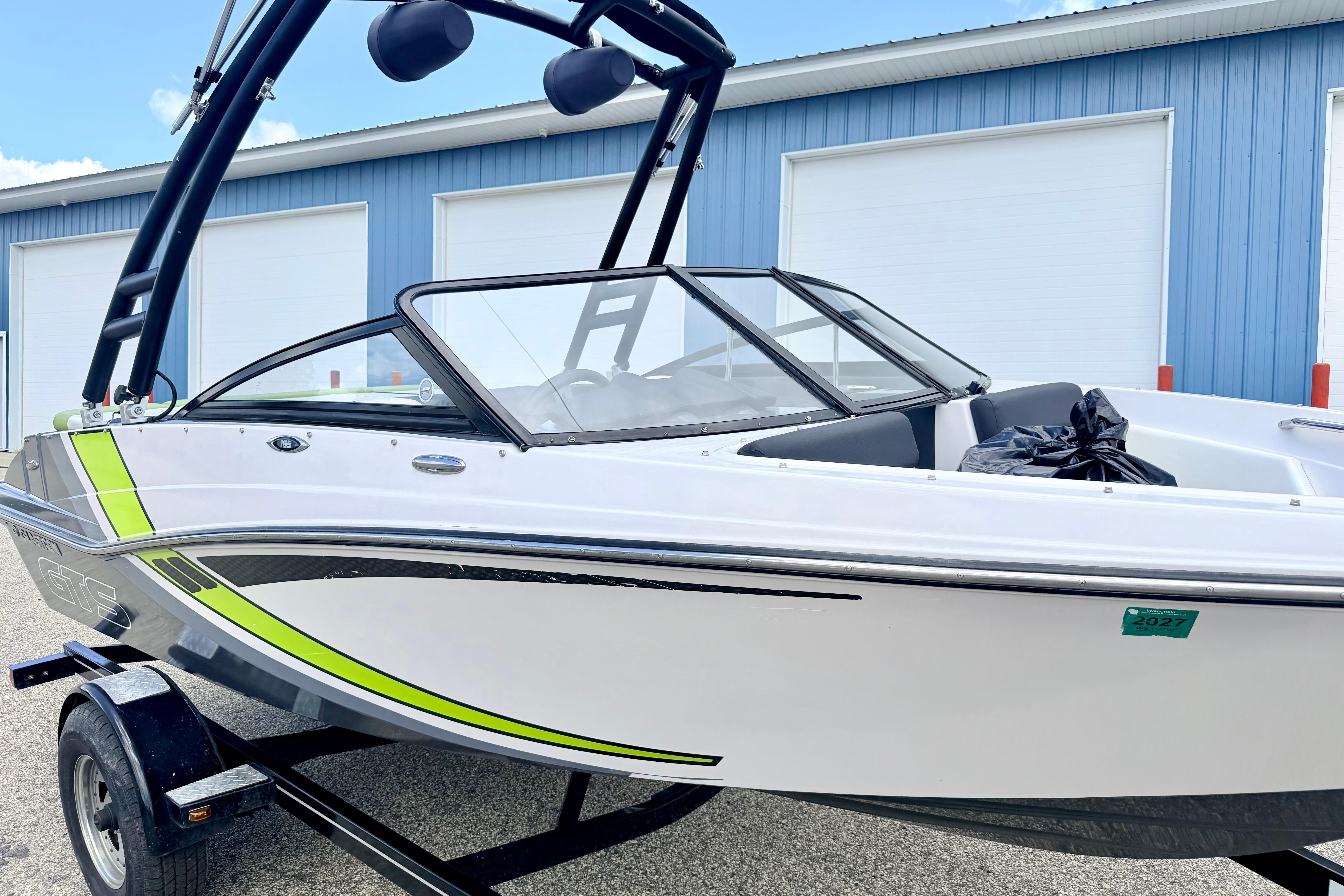 2018 Glastron GT 185 boat with sleek design, parked near blue building.
