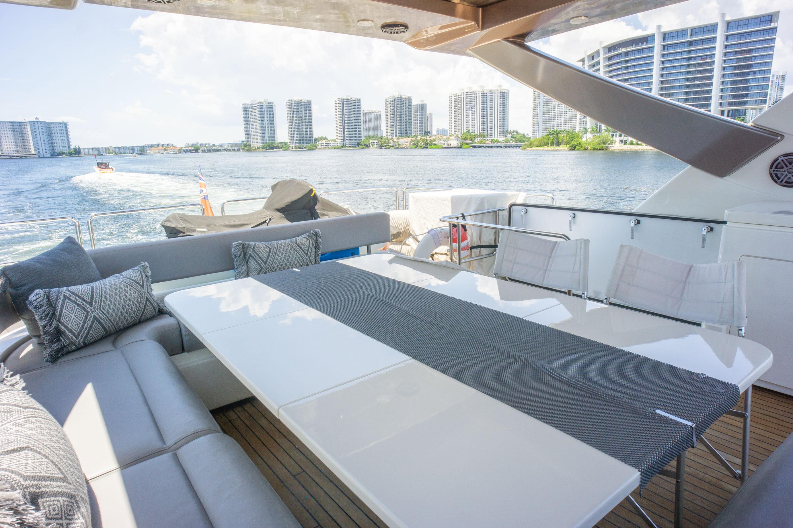 Luxurious 2015 Ferretti Yachts 750 with elegant outdoor seating and scenic waterfront view.