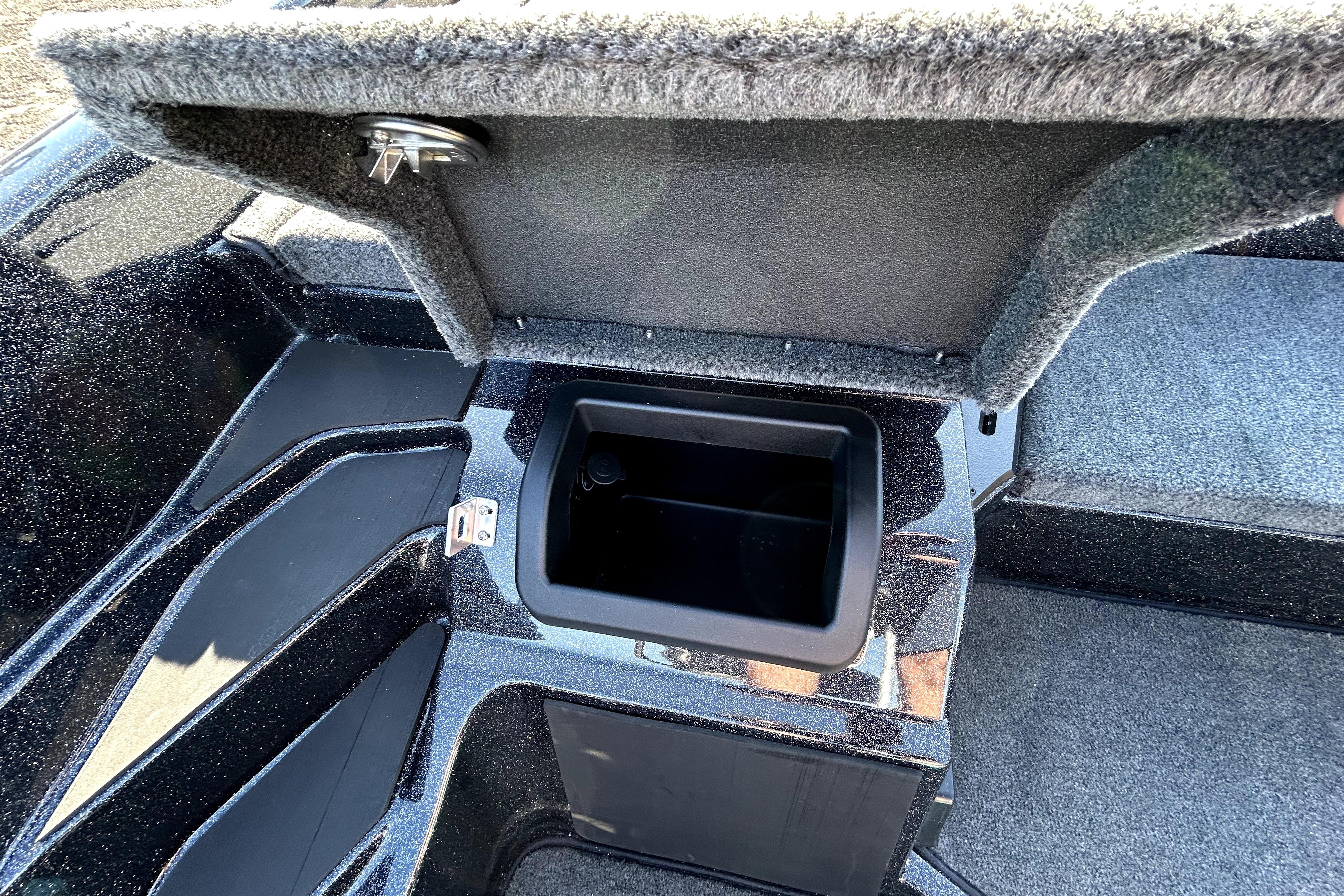 Open storage compartment in 2026 Skeeter ZXE21 boat, featuring carpeted interior and secure latch.