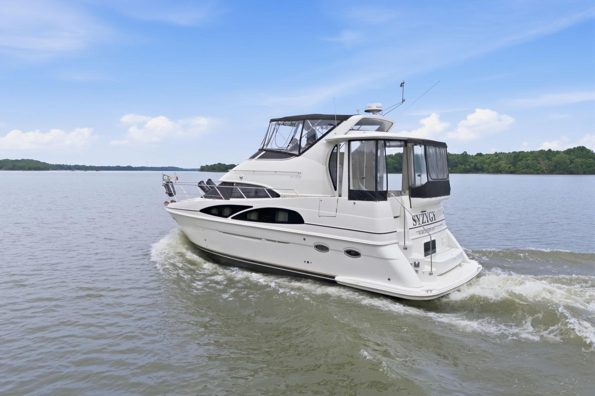 2005 Carver 39 Motor Yacht cruising on a serene lake under a clear blue sky.