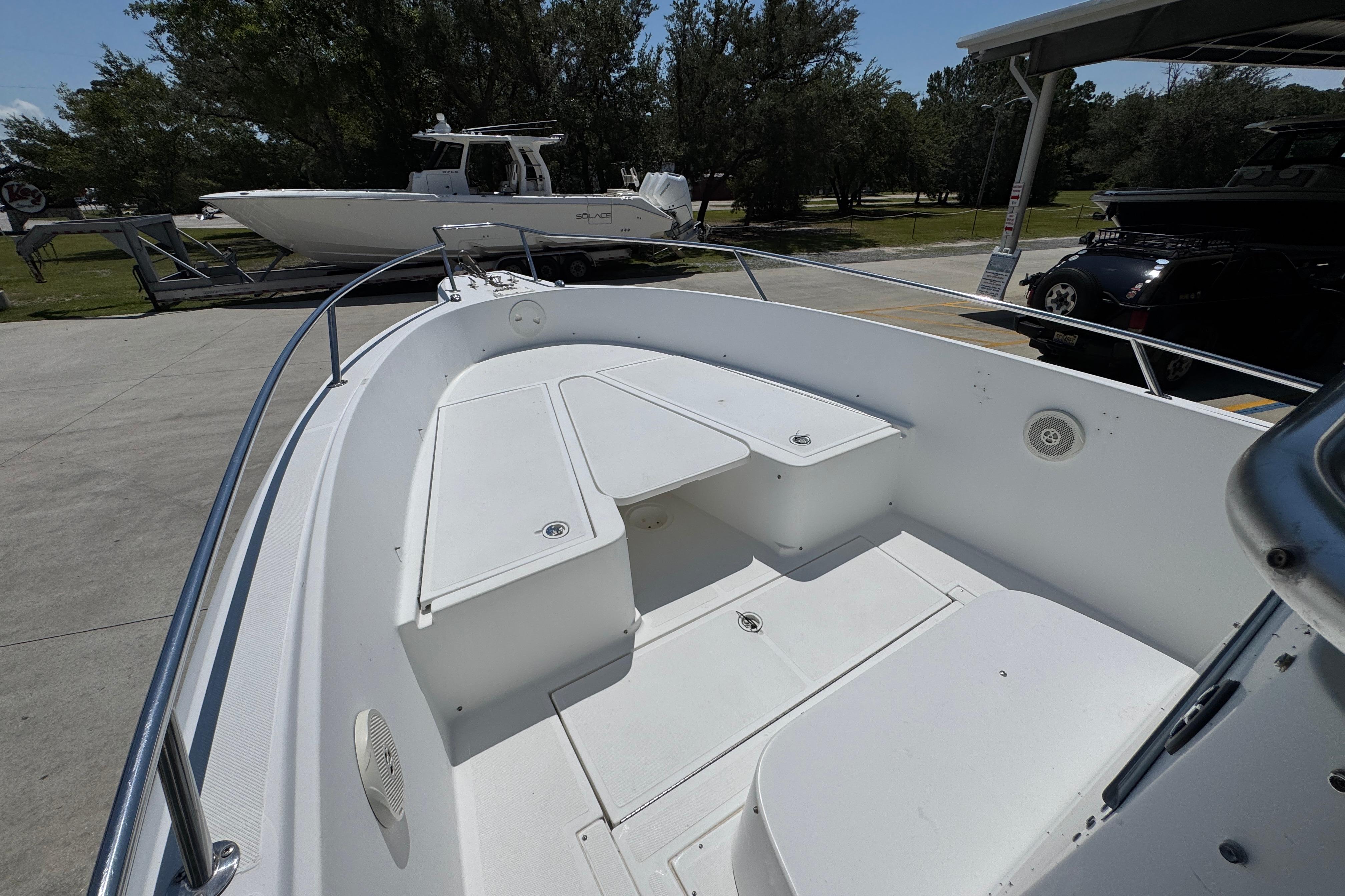 2000 Stamas 250 Tarpon boat interior with seating and storage, parked outdoors.