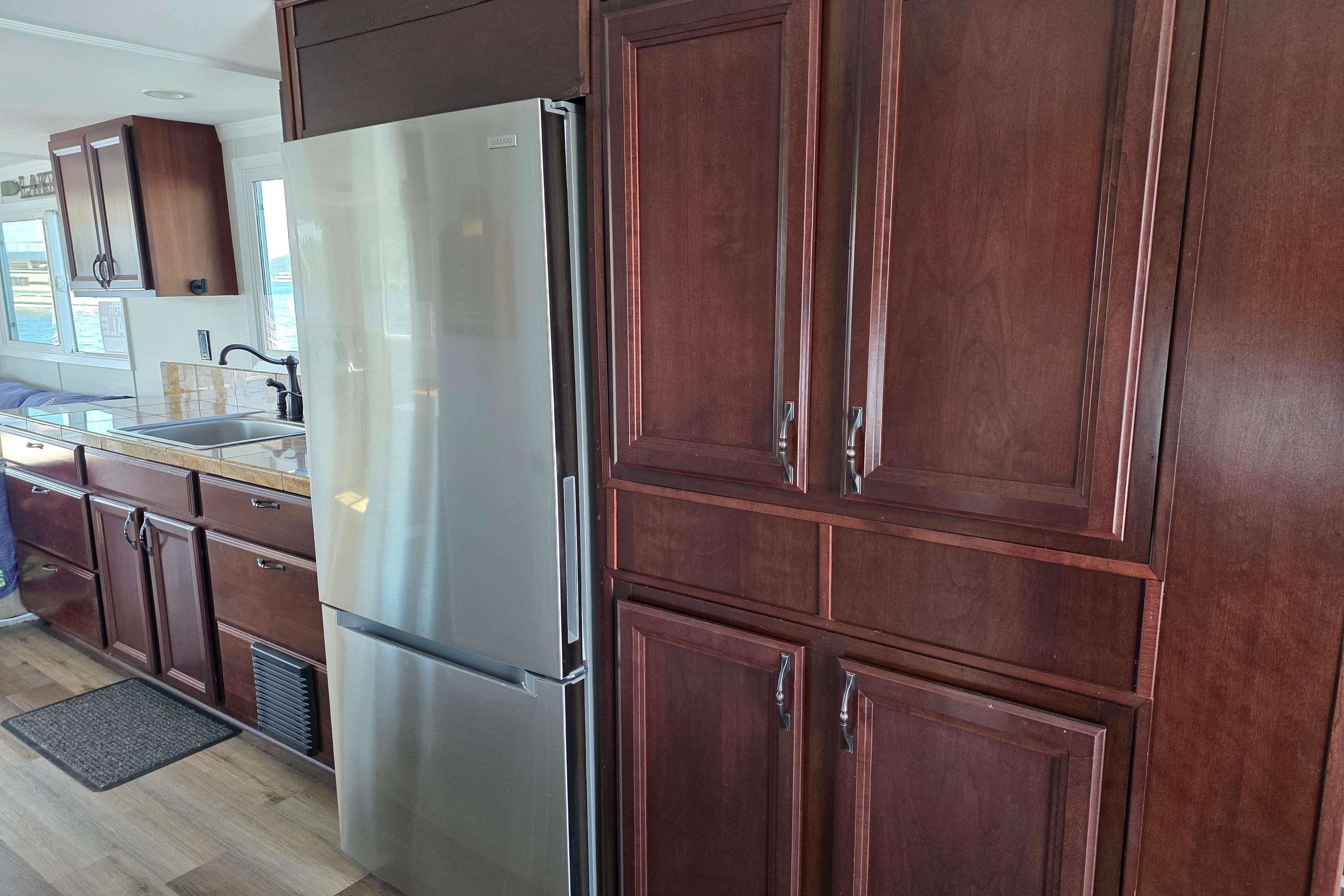 Houseboat kitchen interior with dark wood cabinets and stainless steel refrigerator, 2007 model.