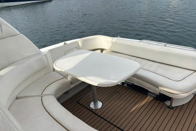 2000 Sea Ray Sundancer 310 boat with white seating and table on deck.