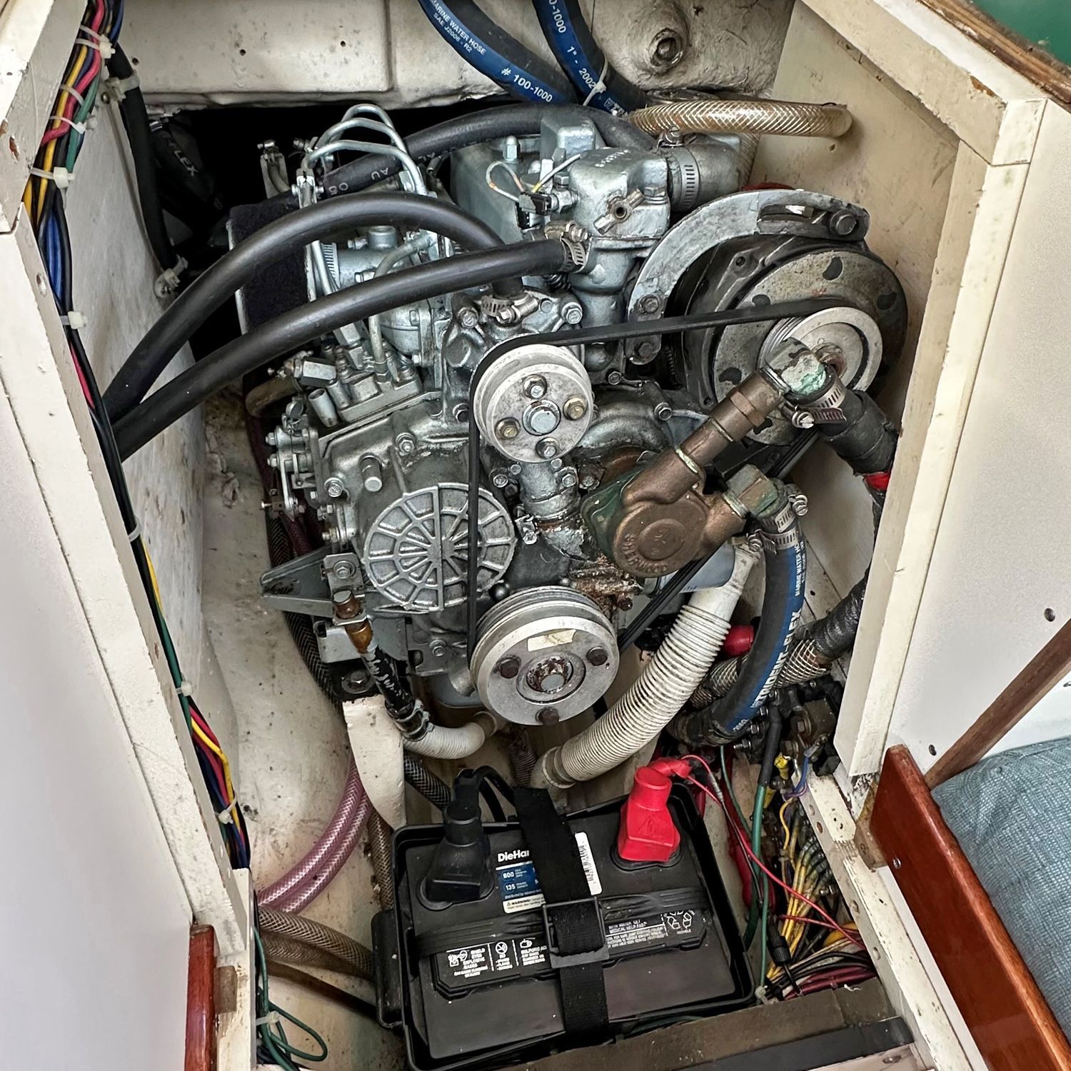An engine compartment with a motor and battery inside a boat.