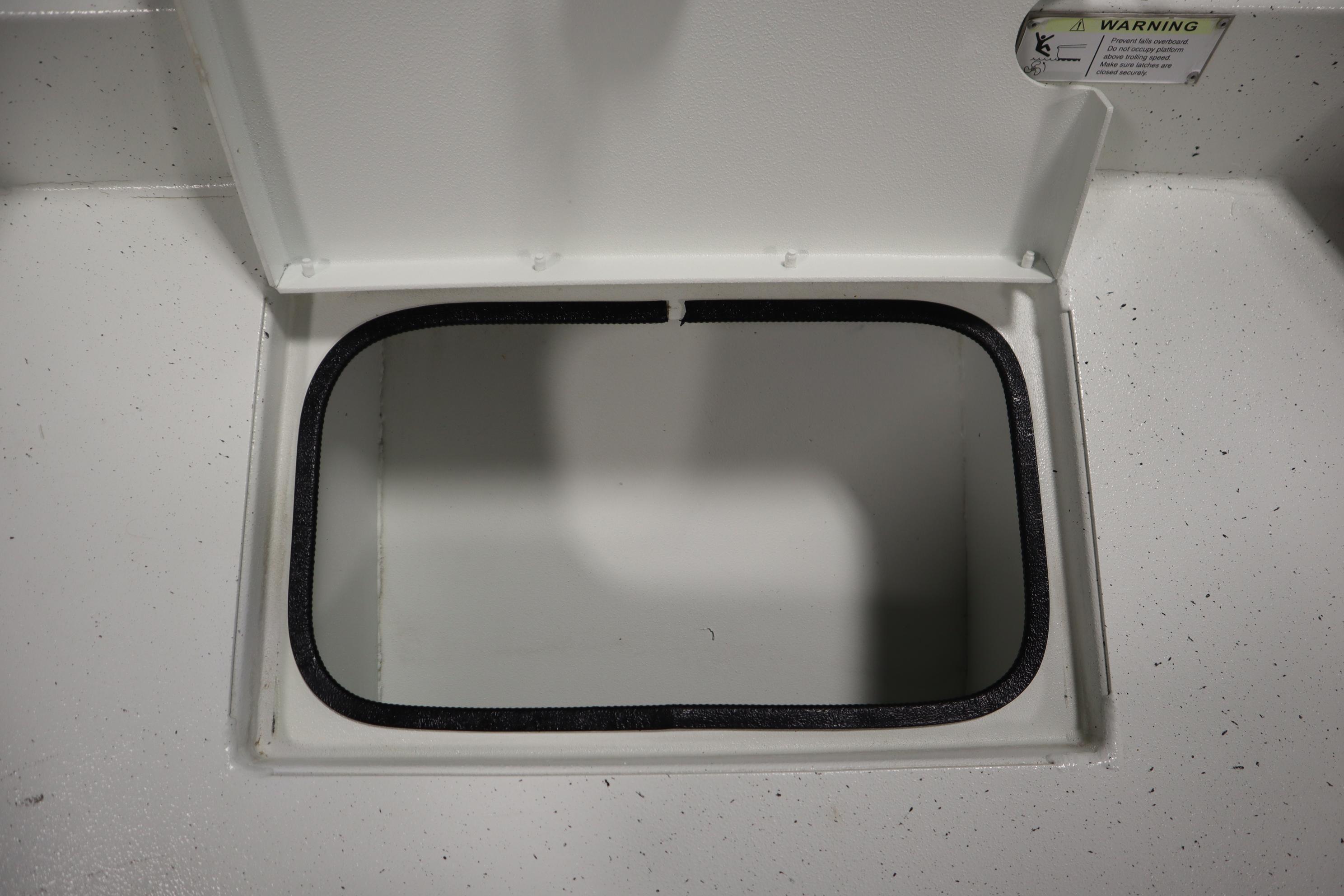 Open storage compartment on 2022 Crestliner 2200 CC boat, featuring a white interior.