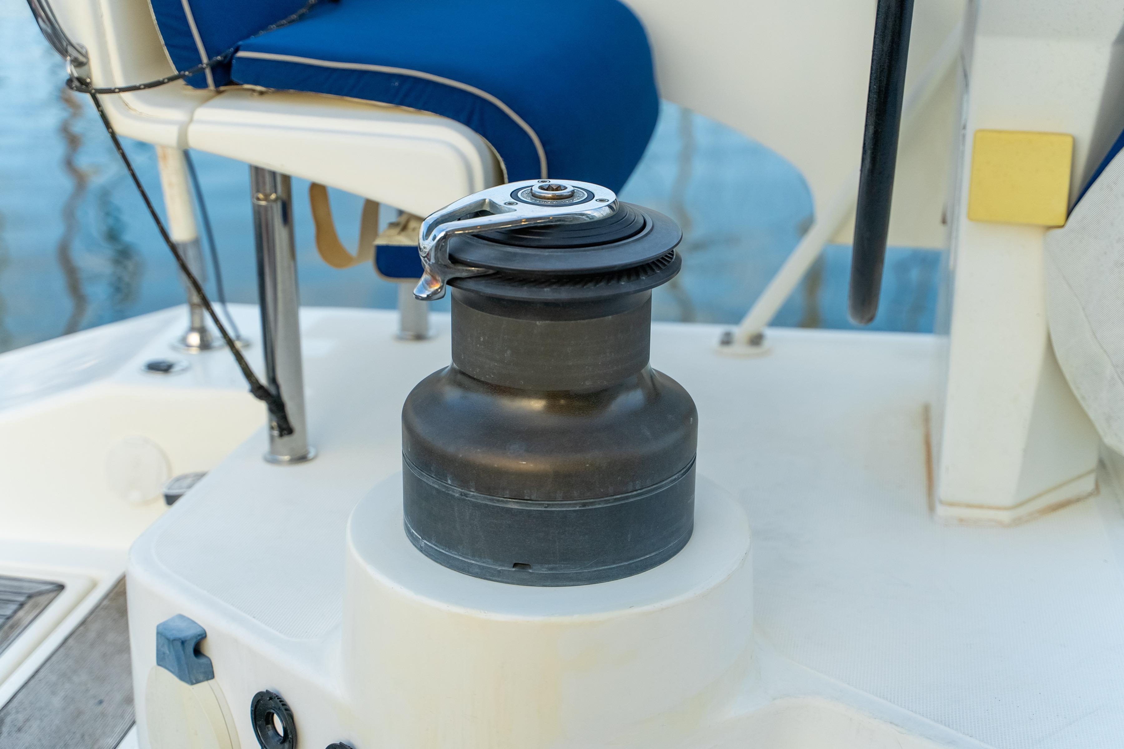 Winch on 2009 Catana 65 yacht deck, featuring blue seating and nautical equipment.