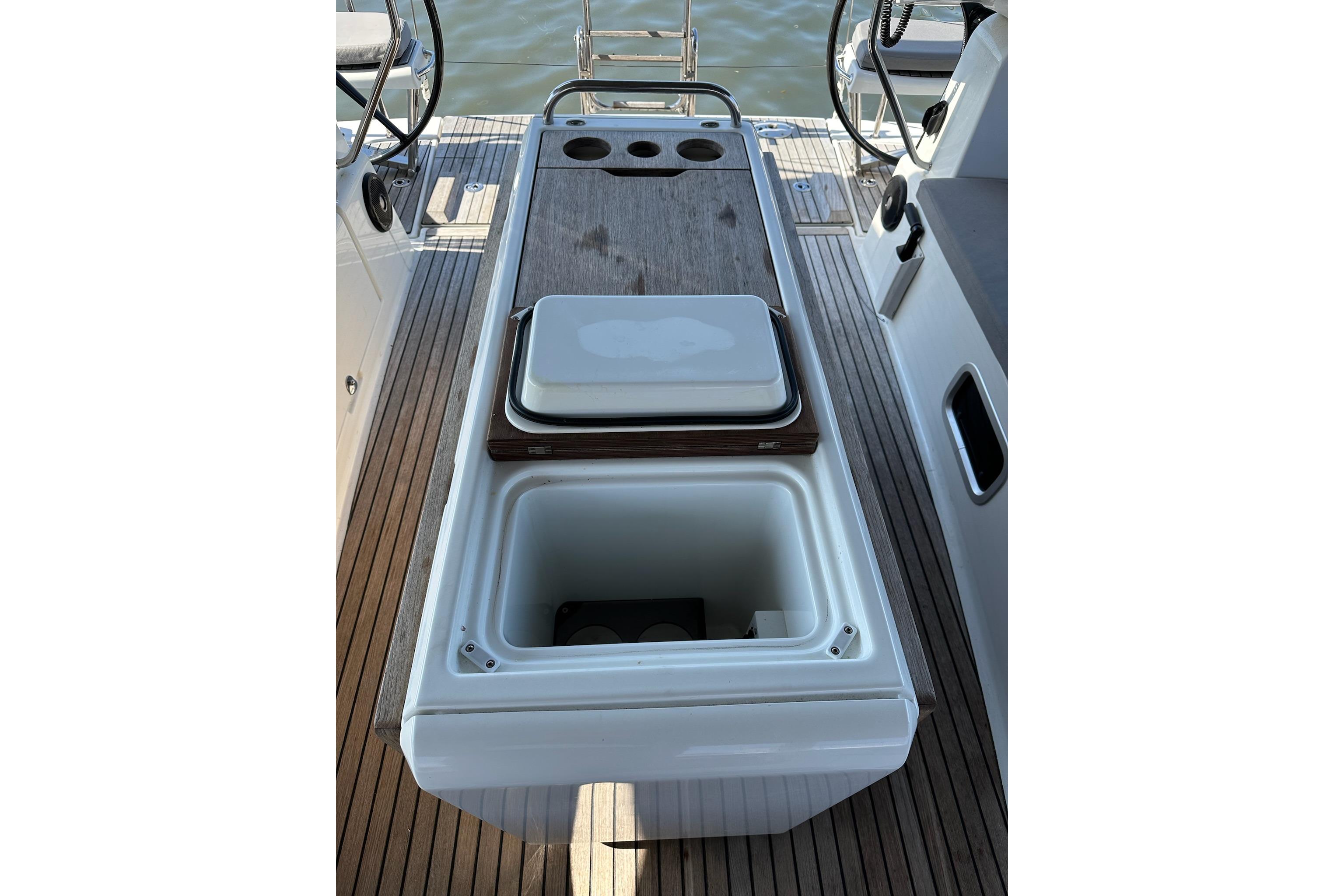 2018 Jeanneau 51 yacht cockpit with open storage compartment and wooden deck.