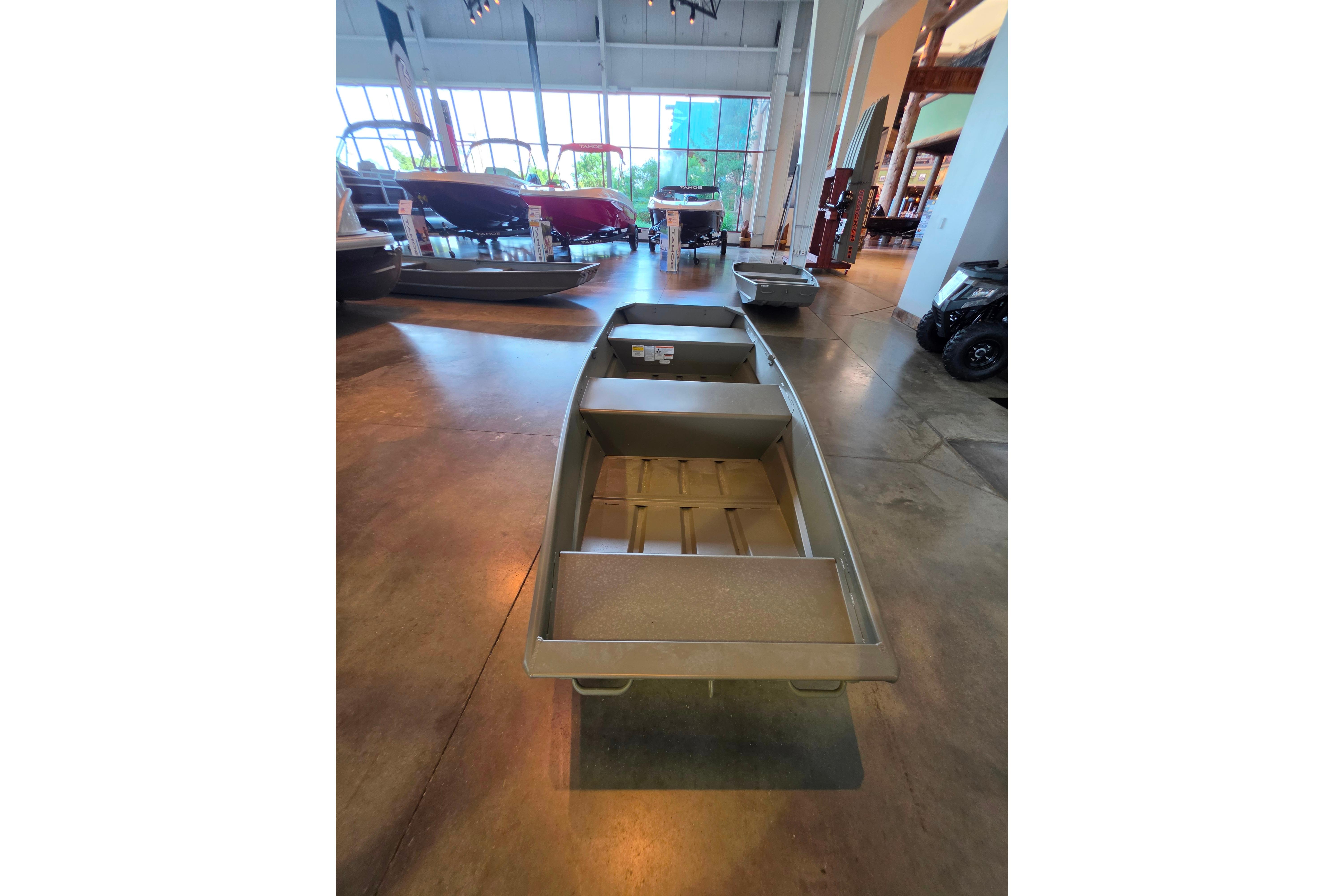 2026 Tracker Grizzly 12 Jon boat displayed in a showroom with other boats.