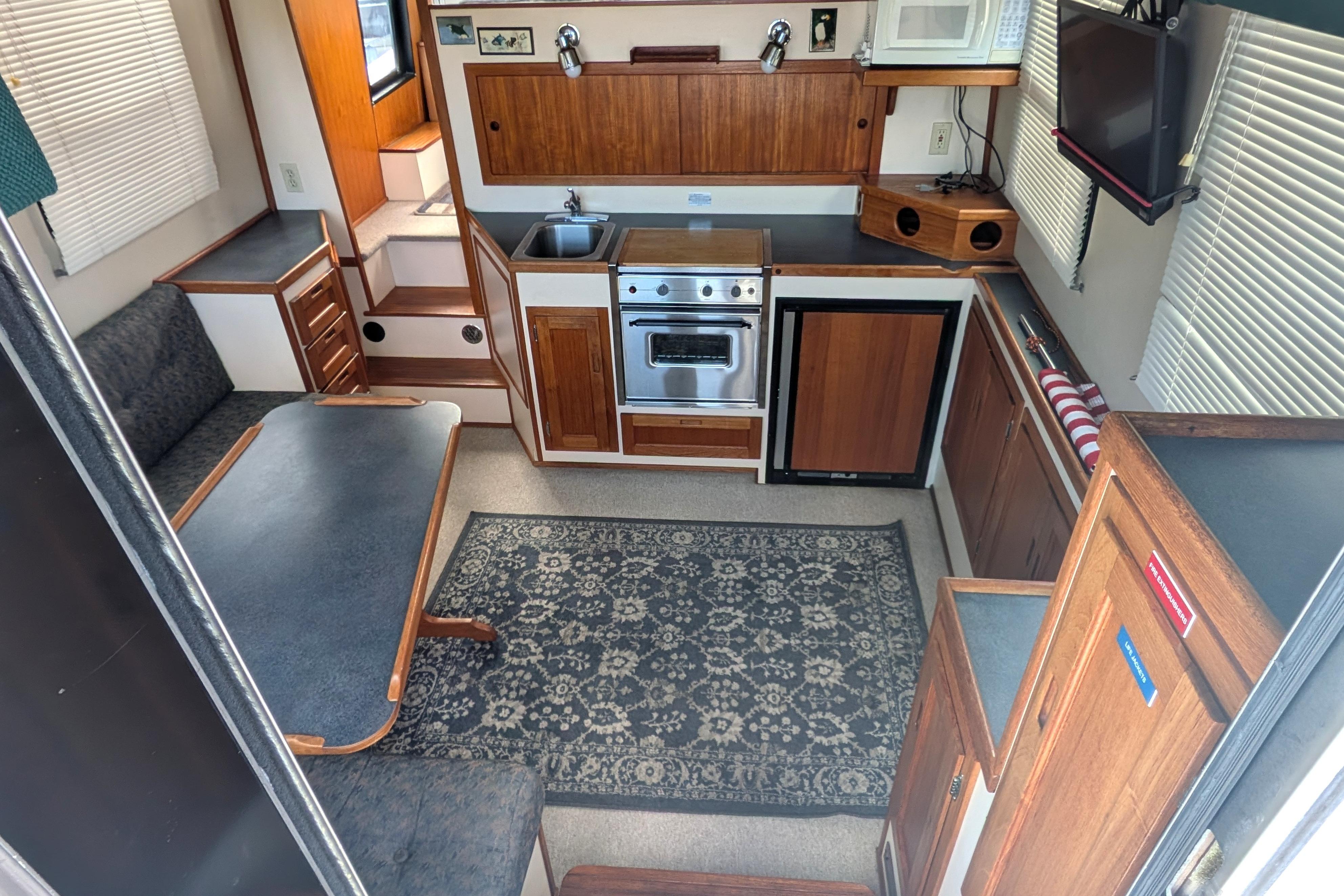 Interior of a 1998 Nordic Tug 32, featuring a cozy kitchen and dining area.