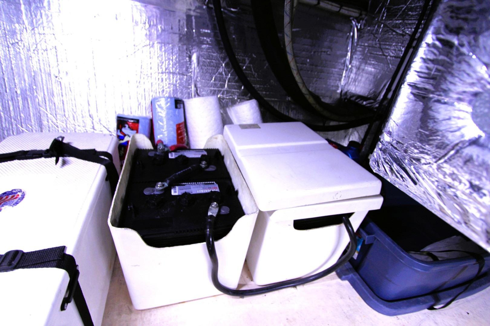 Battery compartment in a 2002 Nordic Tug 37, featuring storage and insulation.