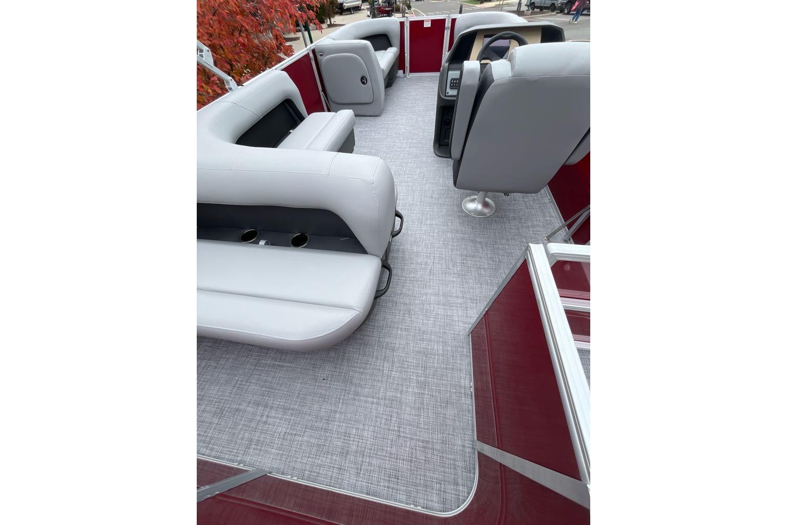 2026 Sun Tracker Party Barge 18 DLX interior with gray seating and red accents.