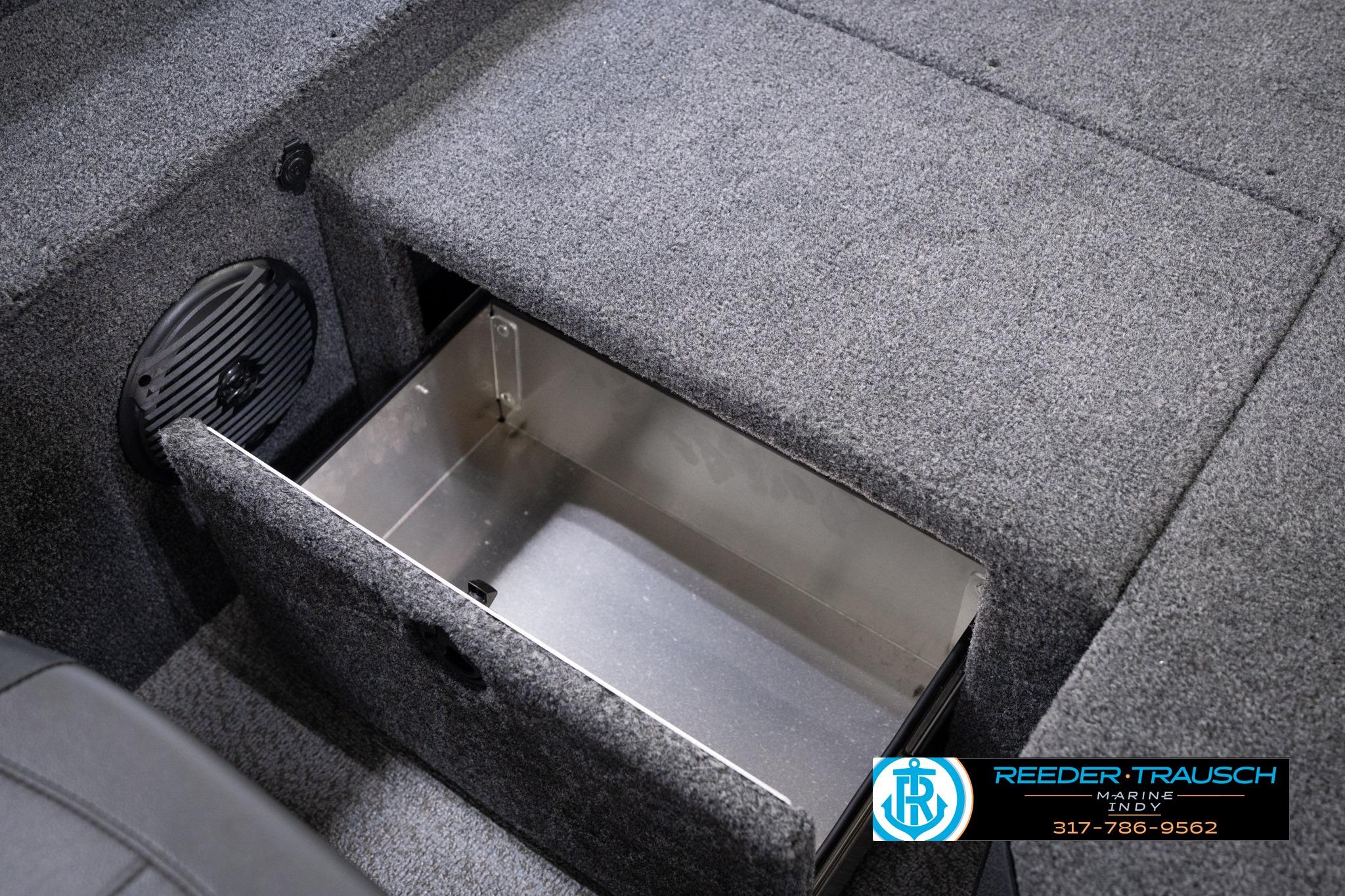 2026 Lund 1775 Impact XS SS boat storage compartment with open hatch, carpeted interior.