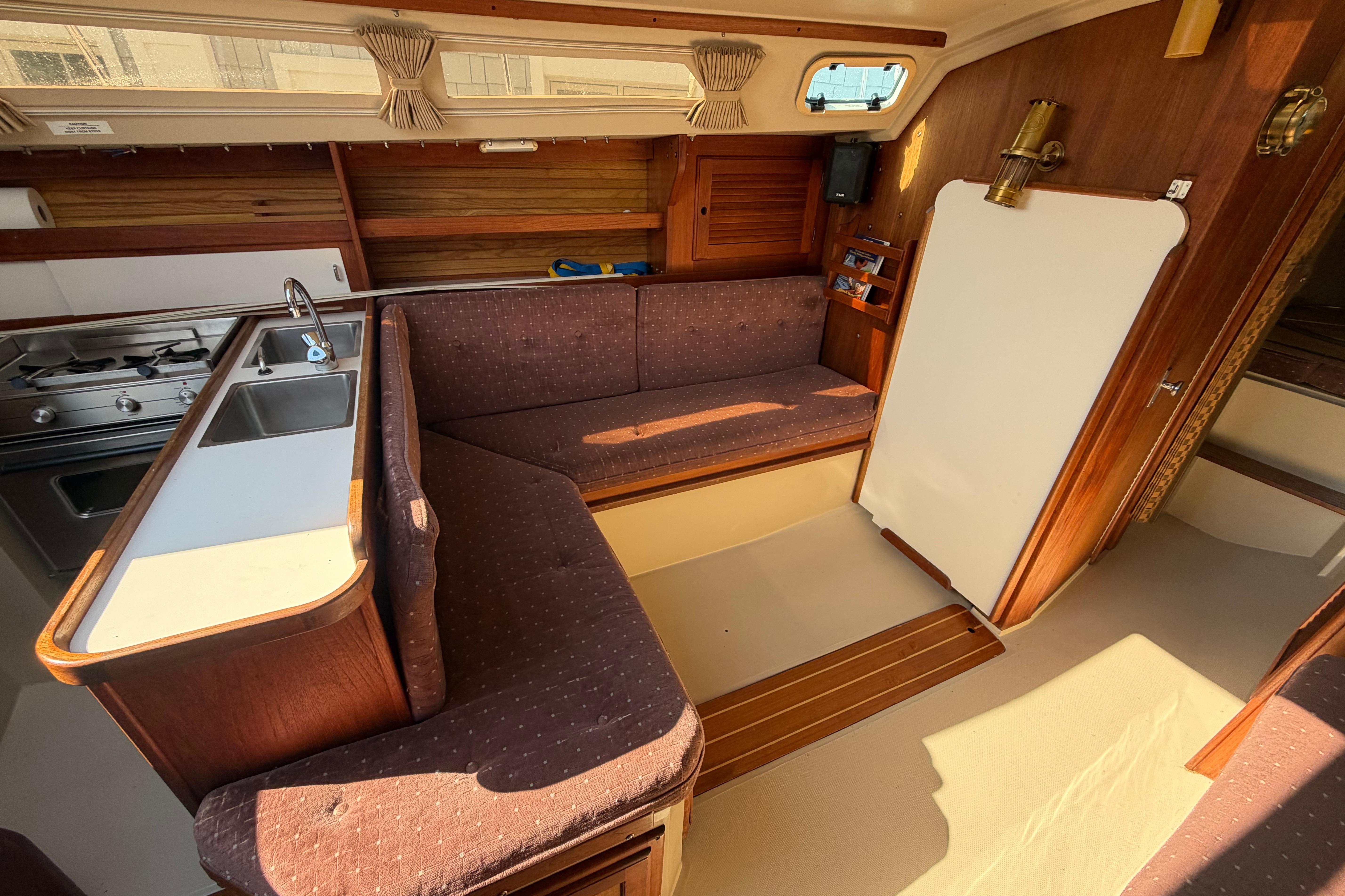 Interior of a 1988 Catalina 30 MkII sailboat with cozy seating and kitchenette.